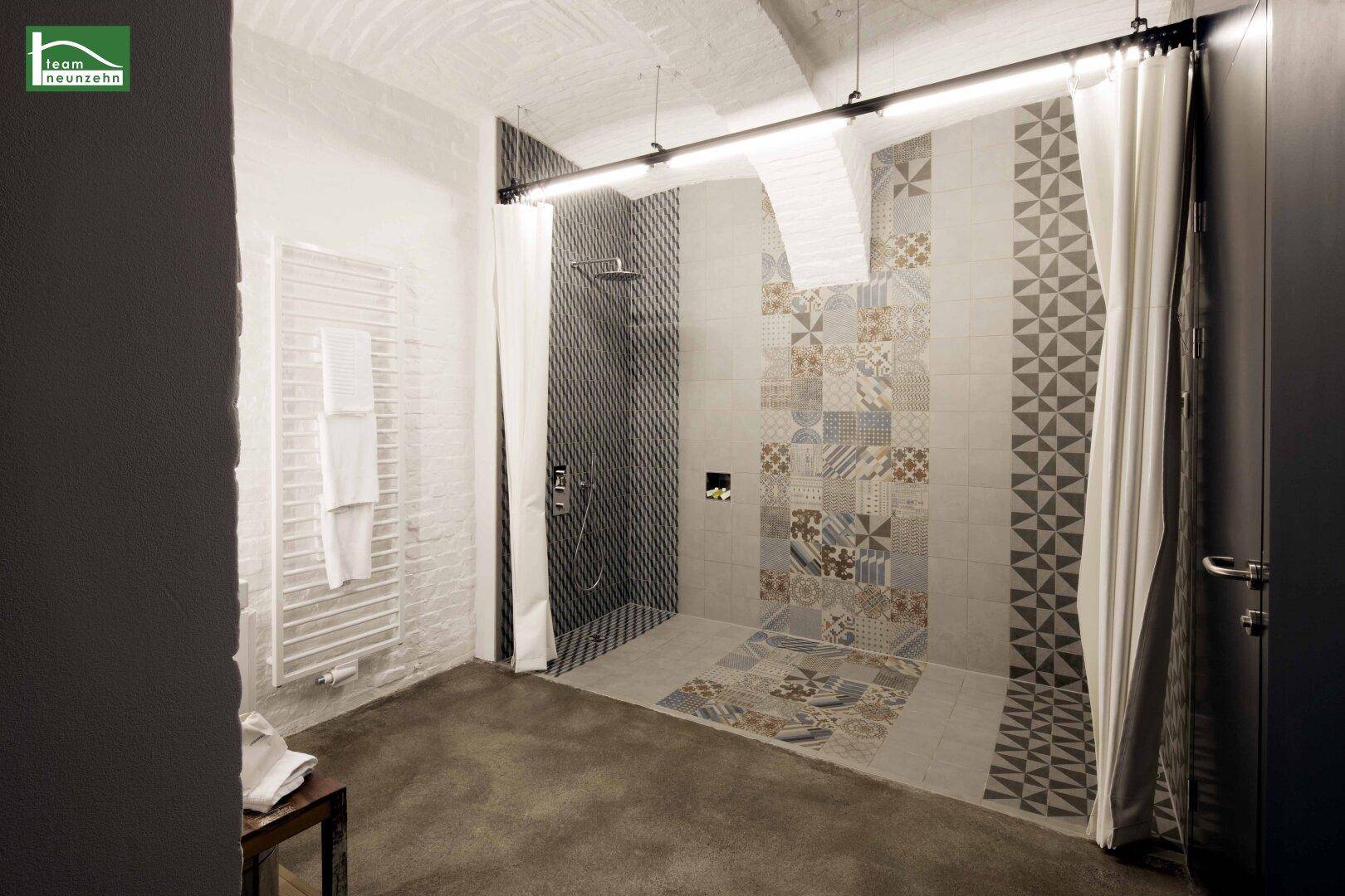 Modernes Badezimmer mit begehbarer Dusche, gemusterten Fliesen und Handtuchheizkörper.