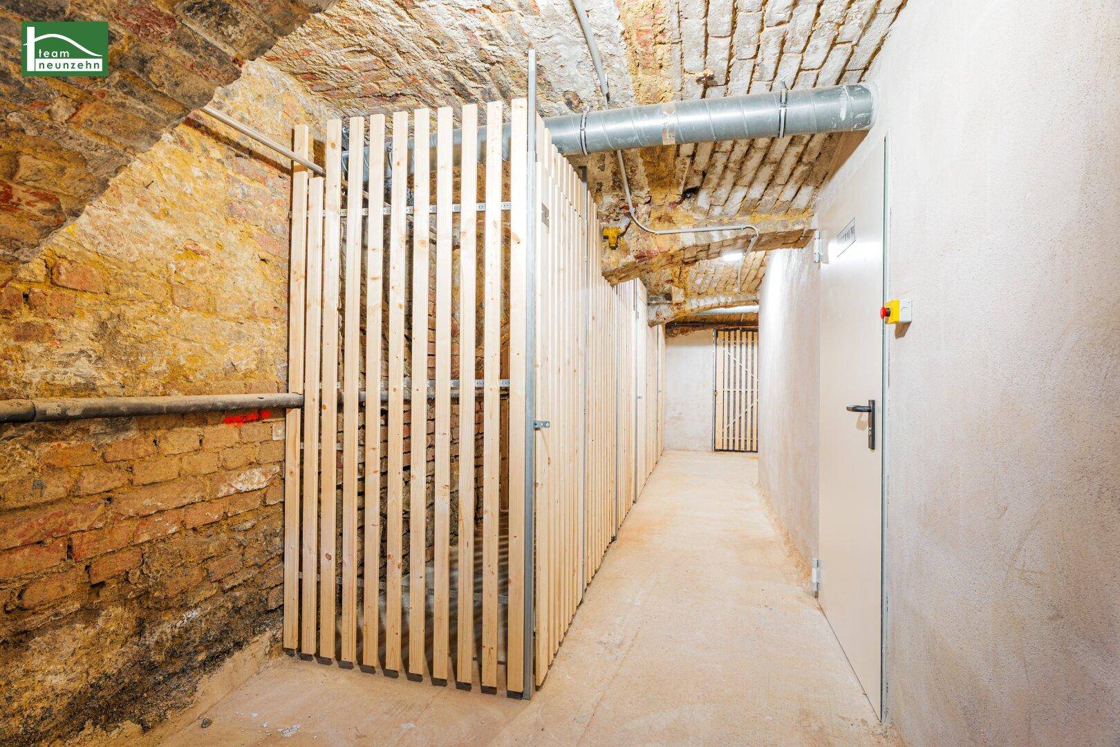 Historischer Kellerraum mit Ziegelgewölbe, unverputzten Wänden und neuen Holzverschlägen.