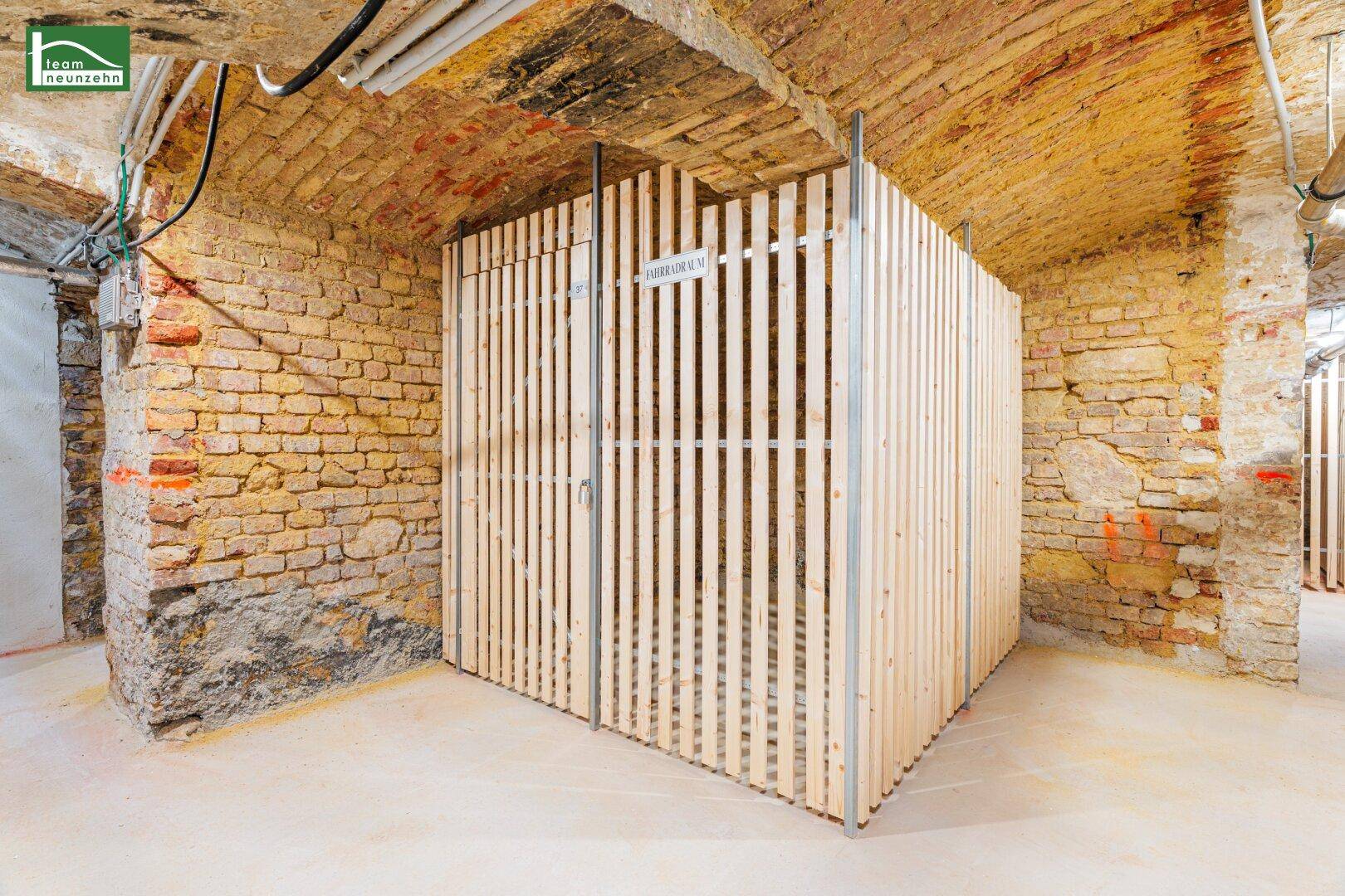 Geräumiger Kellerbereich mit freigelegten Ziegelwänden und modernen Holzverschlägen für Lagerung.