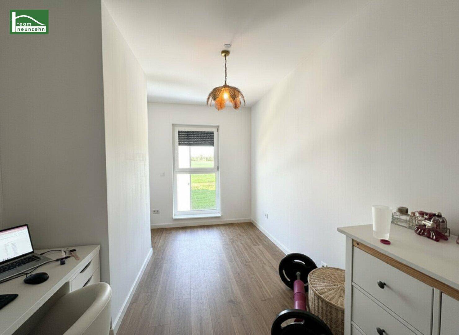 Vielseitiges Zimmer mit Holzboden und Fenster, nutzbar als Büro oder Fitnessraum.
