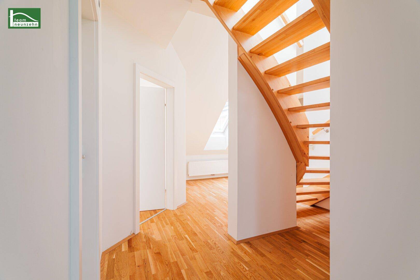 Detailansicht der hellen Holztreppe, die die verschiedenen Ebenen der Wohnung verbindet.