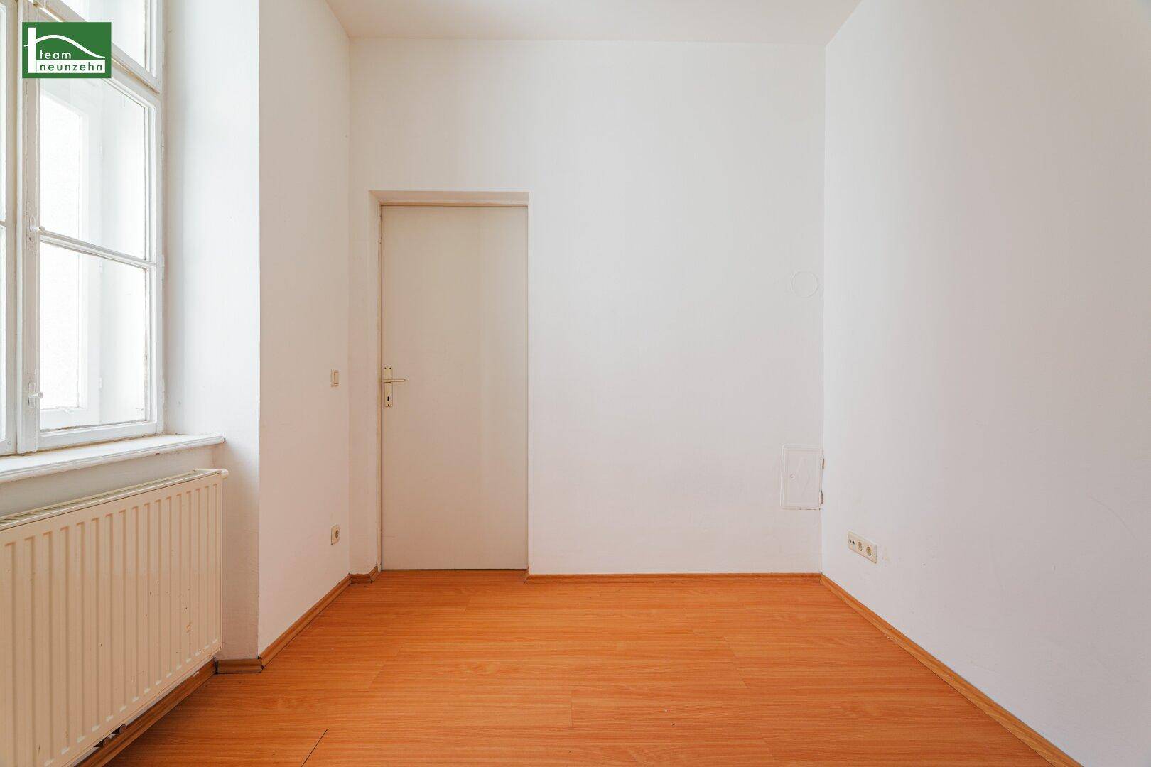 Helles Zimmer mit Holzboden und Fenster, bietet eine angenehme Atmosphäre für Ruhe.