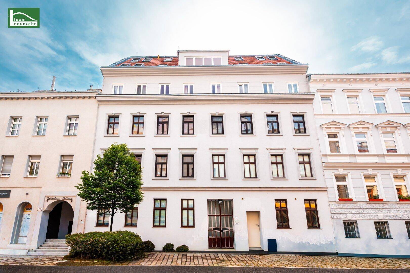 Klassische Fassade eines Mehrfamilienhauses mit vielen Fenstern und traditioneller Architektur.