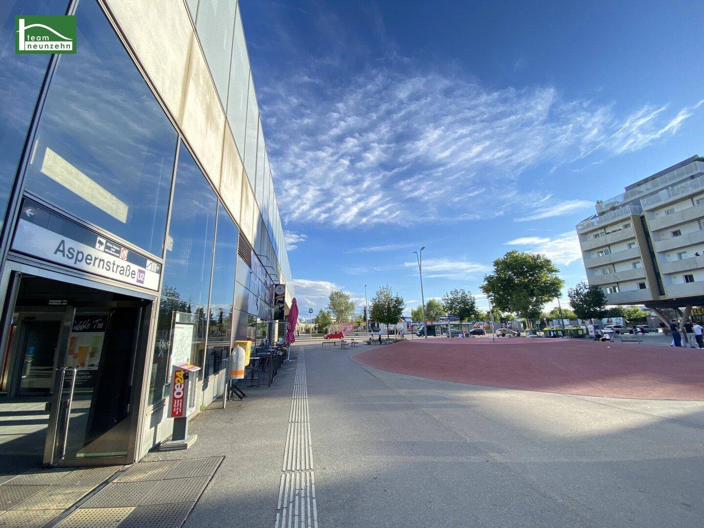 Moderne Glasfassade eines Gebäudes an einer öffentlichen Straße mit blauem Himmel.