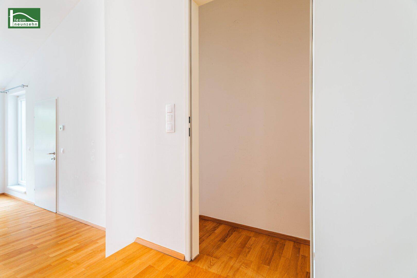 Heller Flur mit Holzboden und Zugang zu weiteren Räumen, schlicht und funktional.