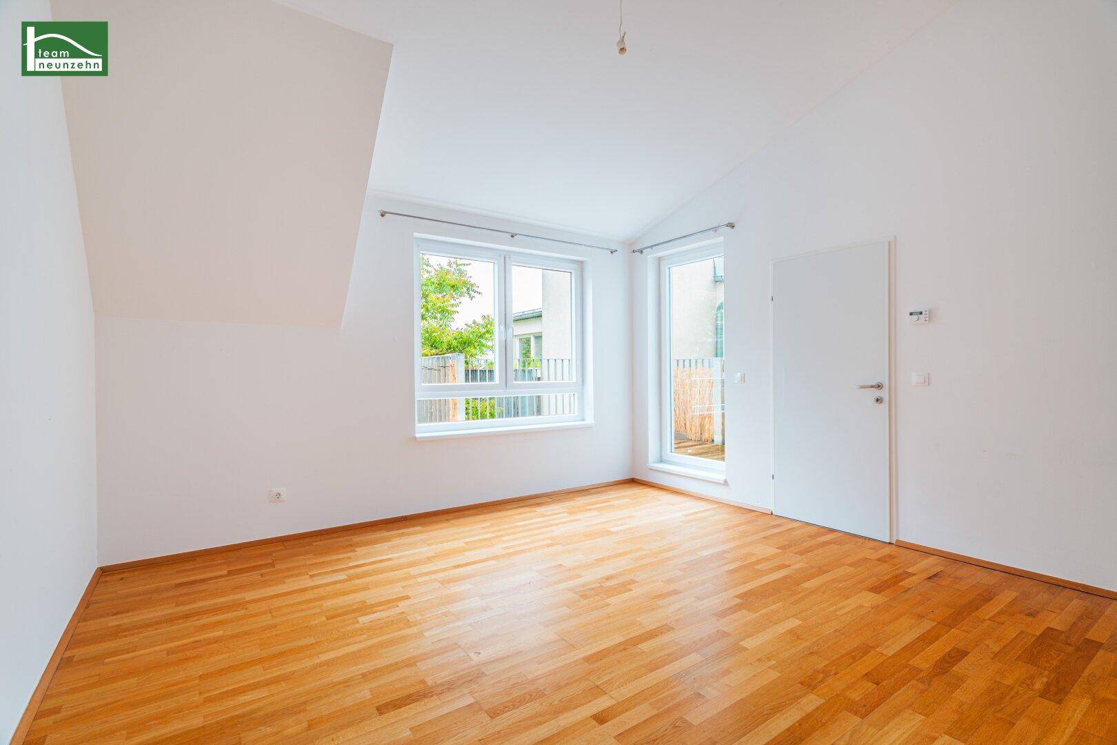 Geräumiges Zimmer mit hellem Holzboden und direktem Zugang zum Außenbereich, vielseitig nutzbar.