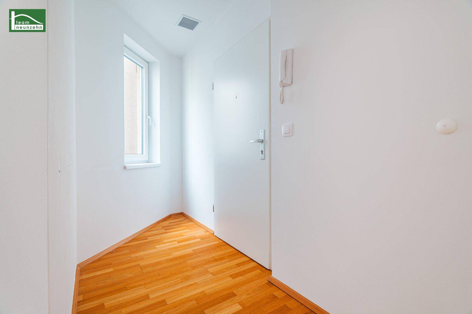 Kleiner Eingangsbereich mit Holzboden und Fenster, bietet natürlichen Lichteinfall.