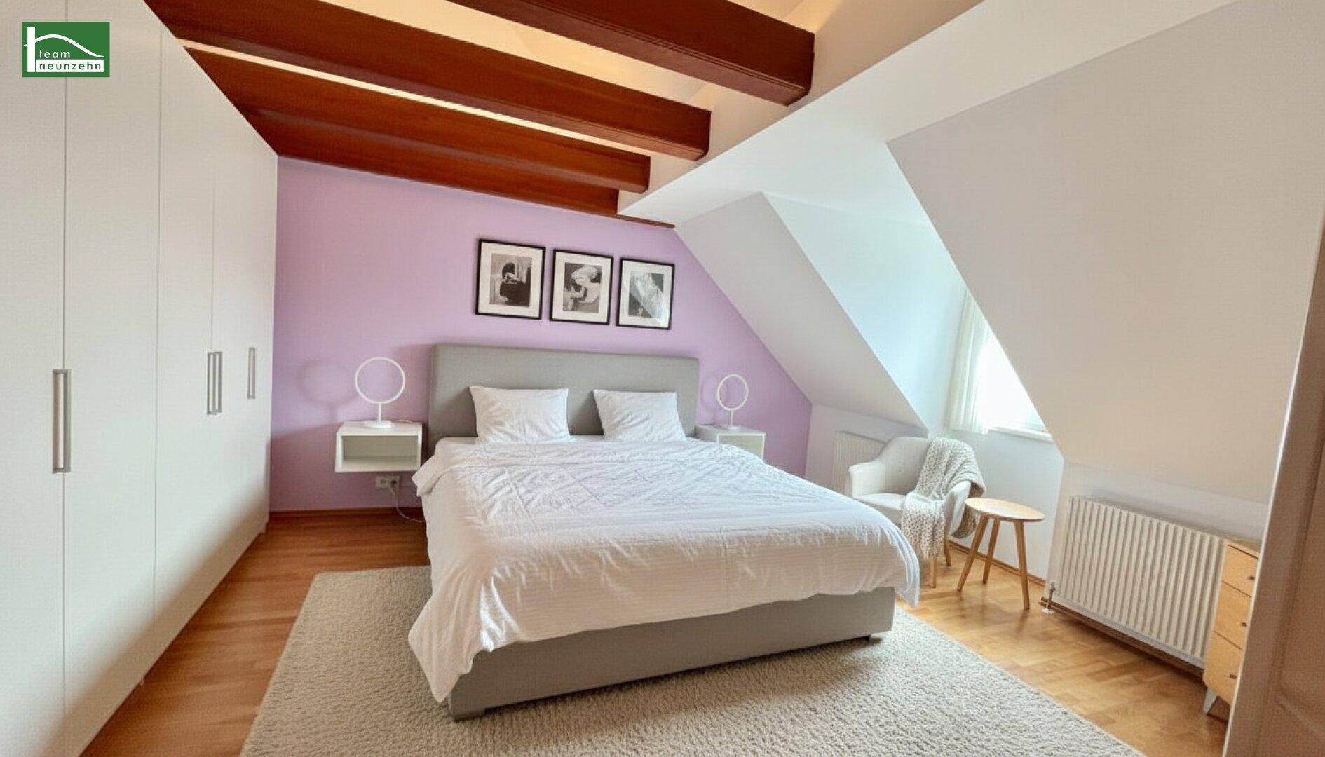Gemütliches Schlafzimmer mit Doppelbett, Einbauschränken, Holzbalken und lila Akzentwand.