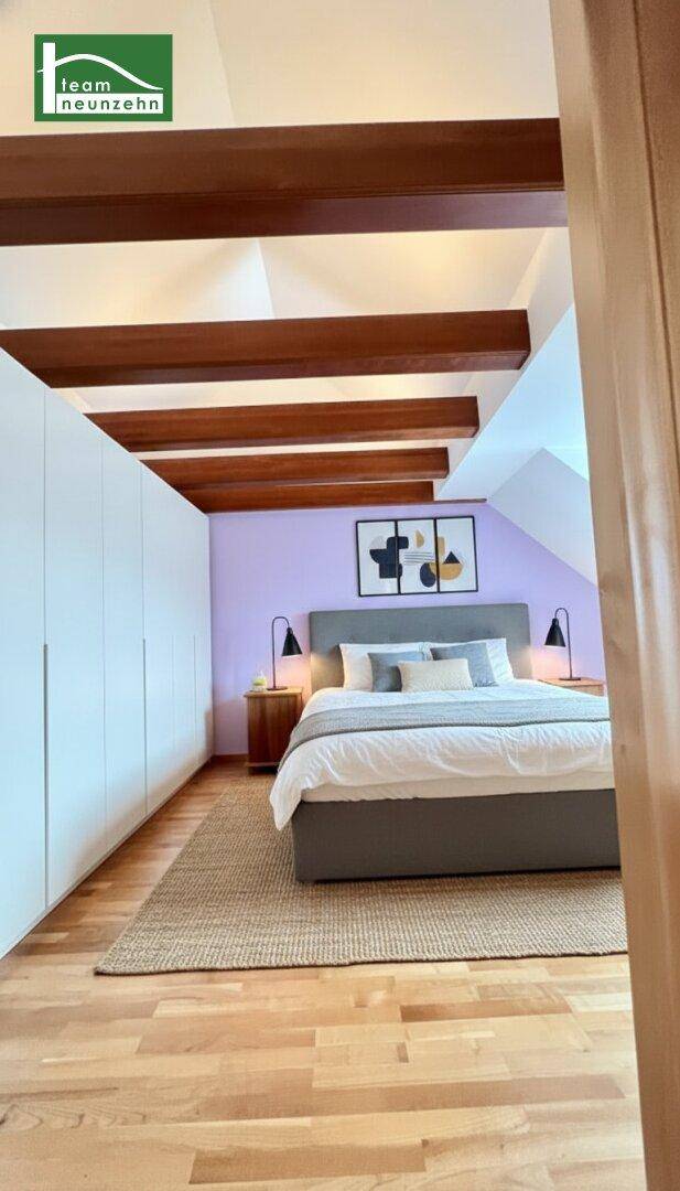 Schlafzimmer mit Holzboden, großen Einbauschränken und sichtbaren Deckenbalken, die Charakter verleihen.