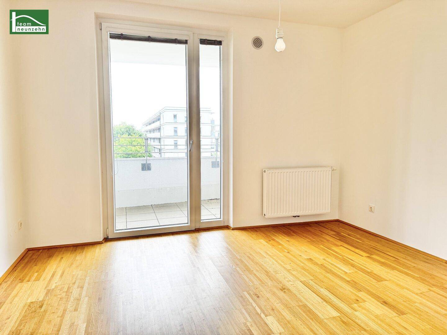 Helles Zimmer mit großem Fenster und Balkonzugang, ideal als Schlaf- oder Arbeitszimmer.