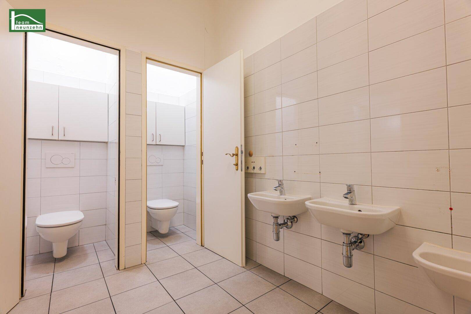 Großer Waschraum mit mehreren Waschbecken und Toiletten, ideal für gewerbliche Nutzung.