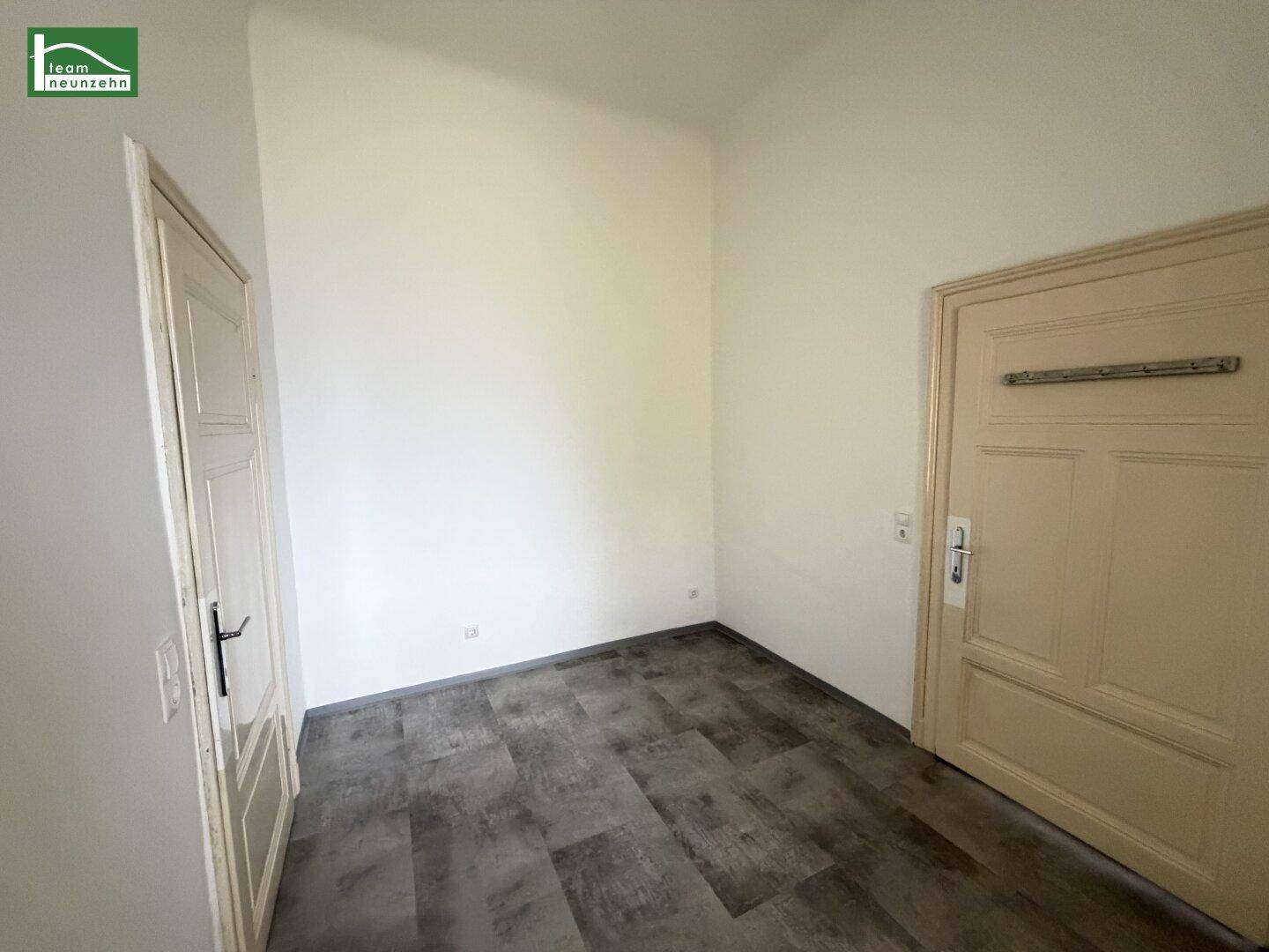 Kleiner, leerer Raum mit dunklem Vinylboden, ideal als Abstellraum oder Speisekammer.