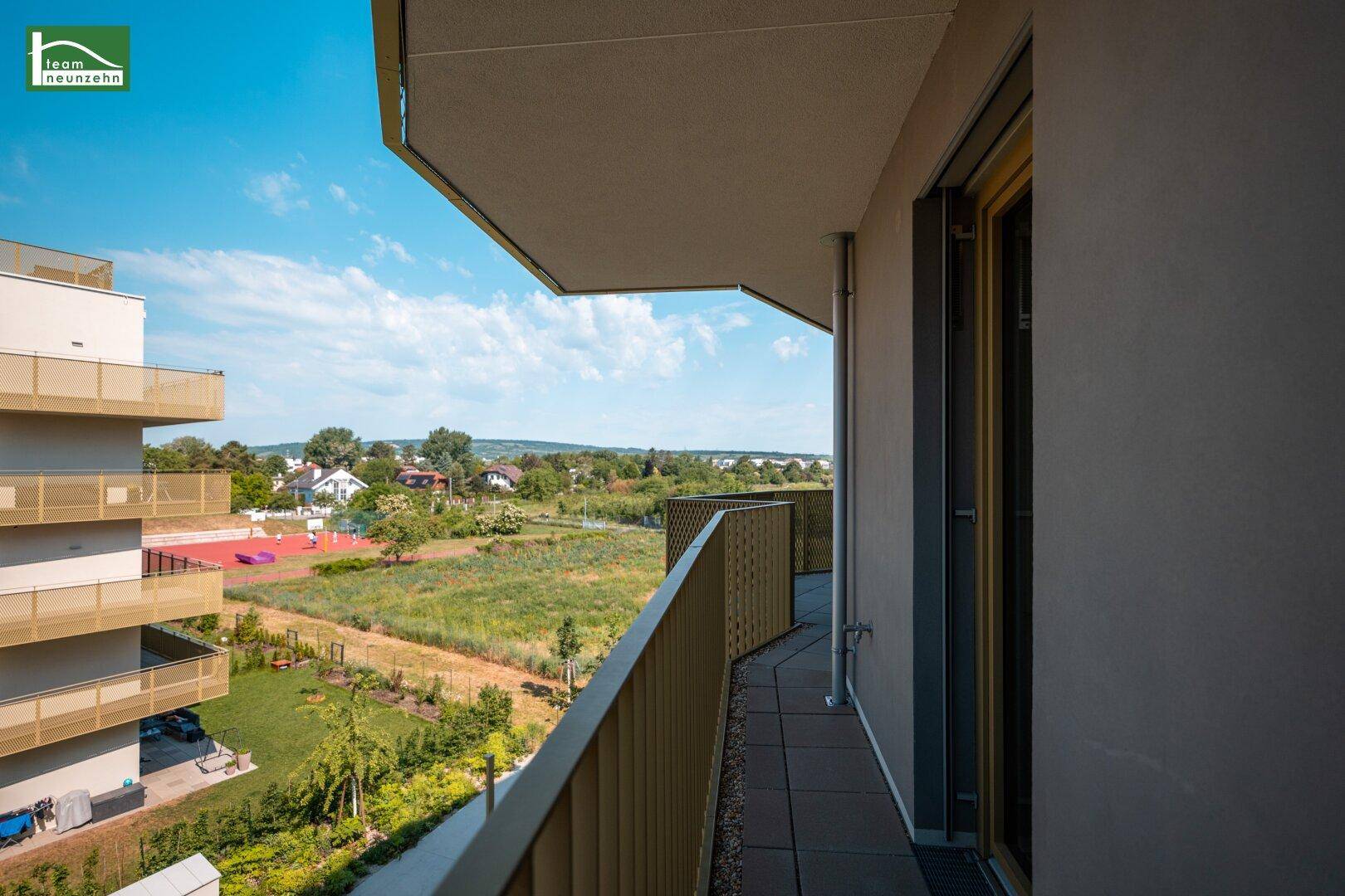 Sonniger Balkon mit weitem Ausblick auf die grüne Umgebung und die ländliche Landschaft.