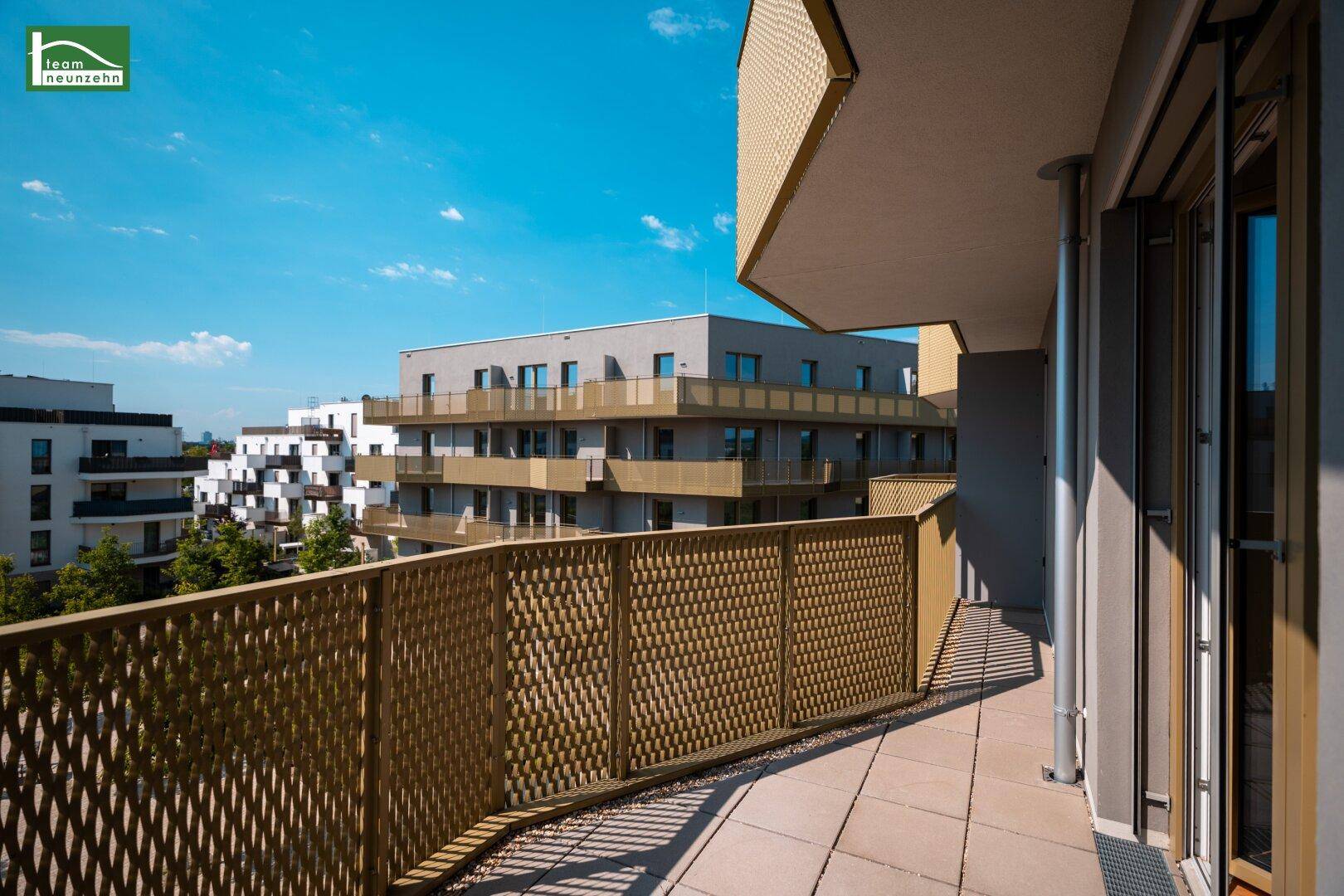 Geräumiger Balkon mit moderner Gitterbrüstung und Blick auf die umliegenden Wohngebäude.
