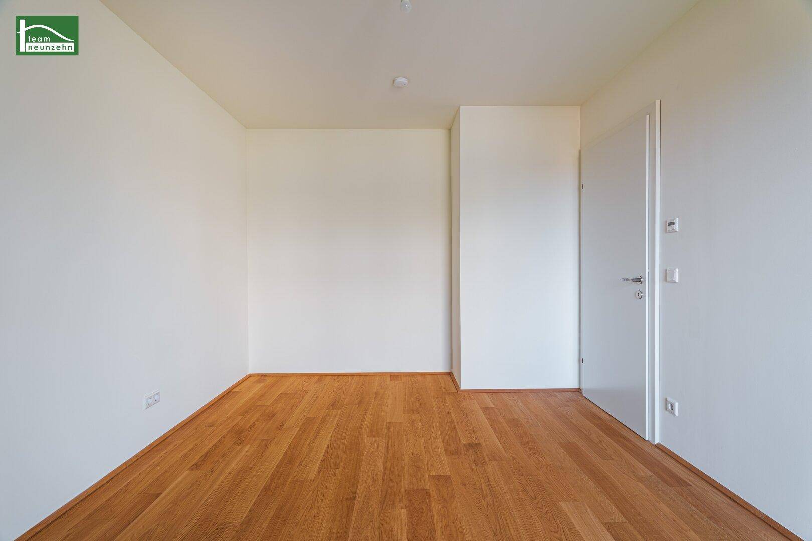 Leerer Raum mit Parkettboden und weiß gestrichenen Wänden, bietet vielseitige Nutzungsmöglichkeiten.
