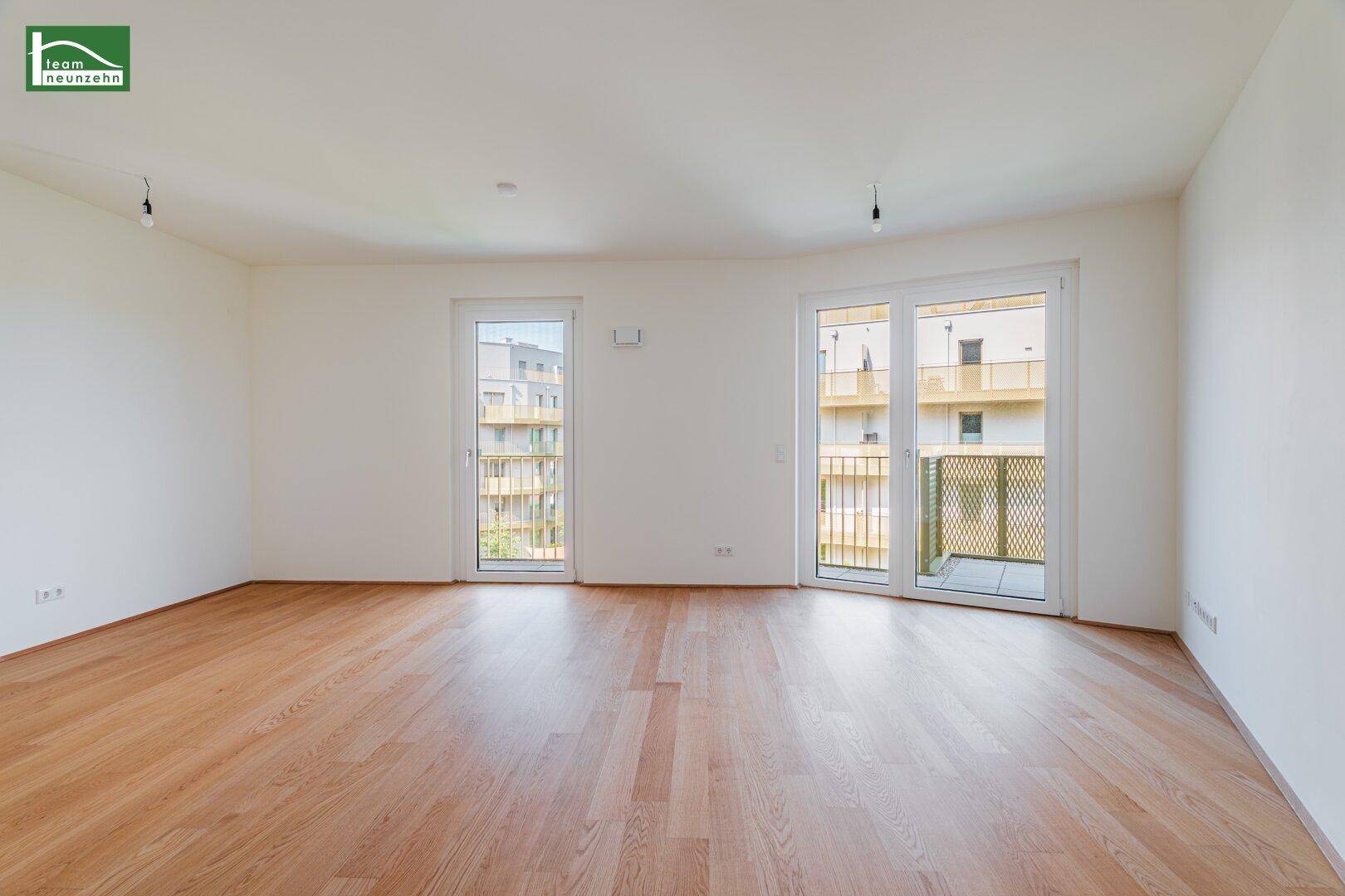 Helles Wohnzimmer mit Parkettboden und Zugang zu zwei Balkonen, ideal für neue Einrichtung.