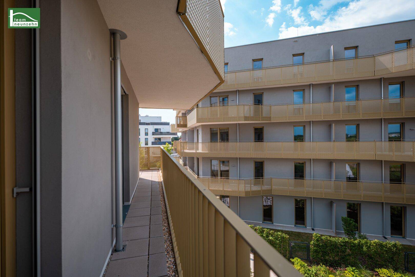 Langer Balkon mit modernem Geländer und Blick auf die umliegenden Gebäude.