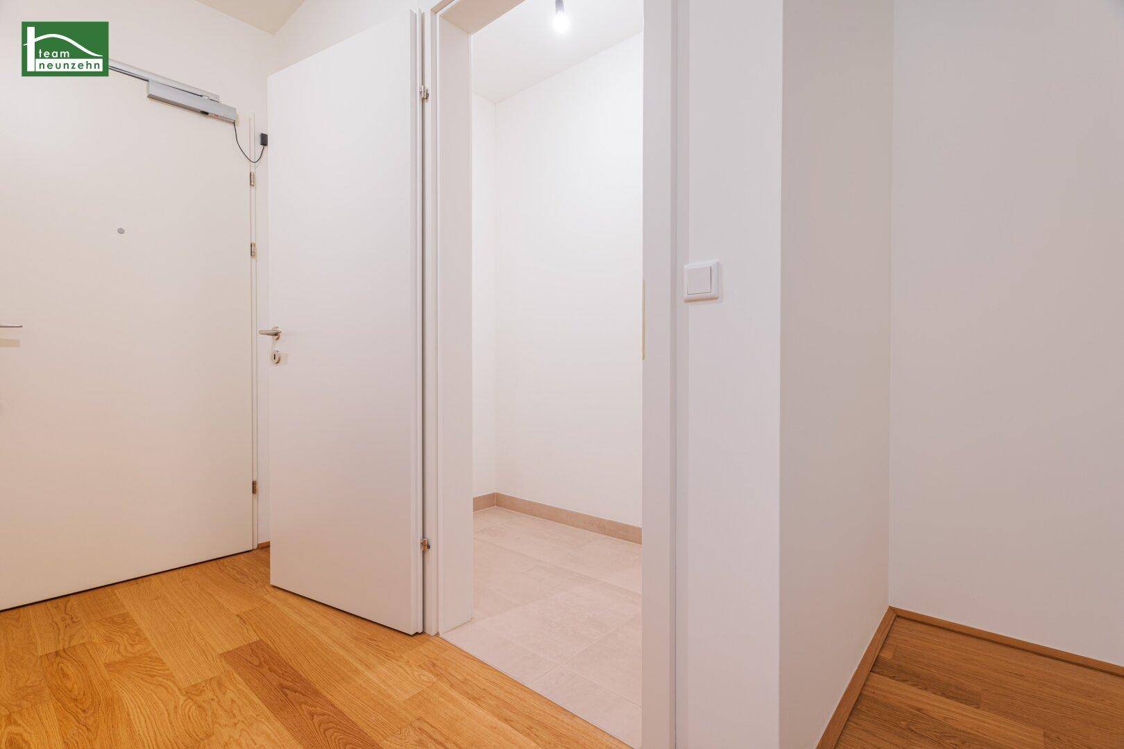 Heller Flur mit Holzboden und Zugang zu einem praktischen Abstellraum.