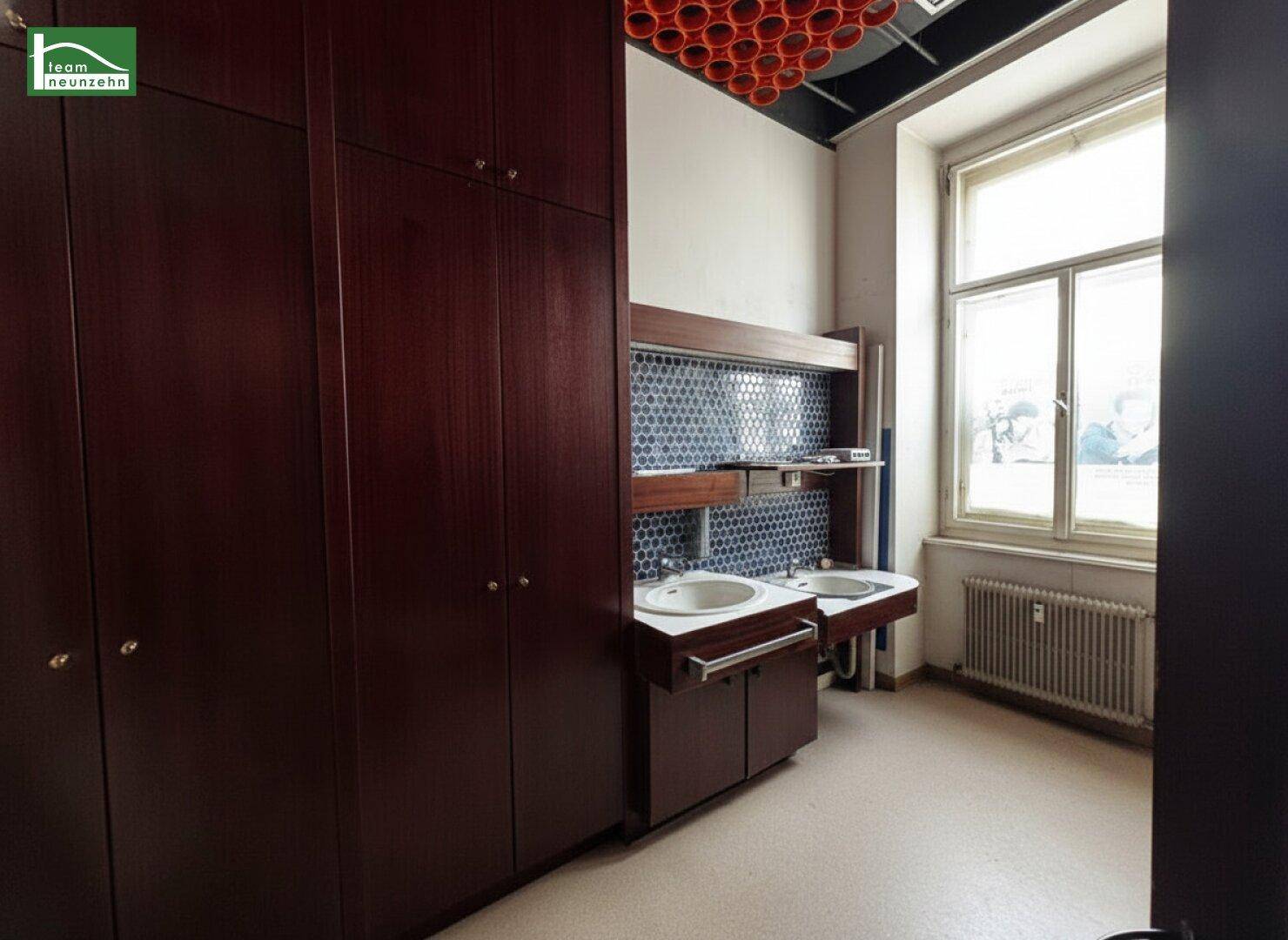 Funktionales Badezimmer mit zwei Waschbecken, integrierten Schränken und einem großen Fenster.