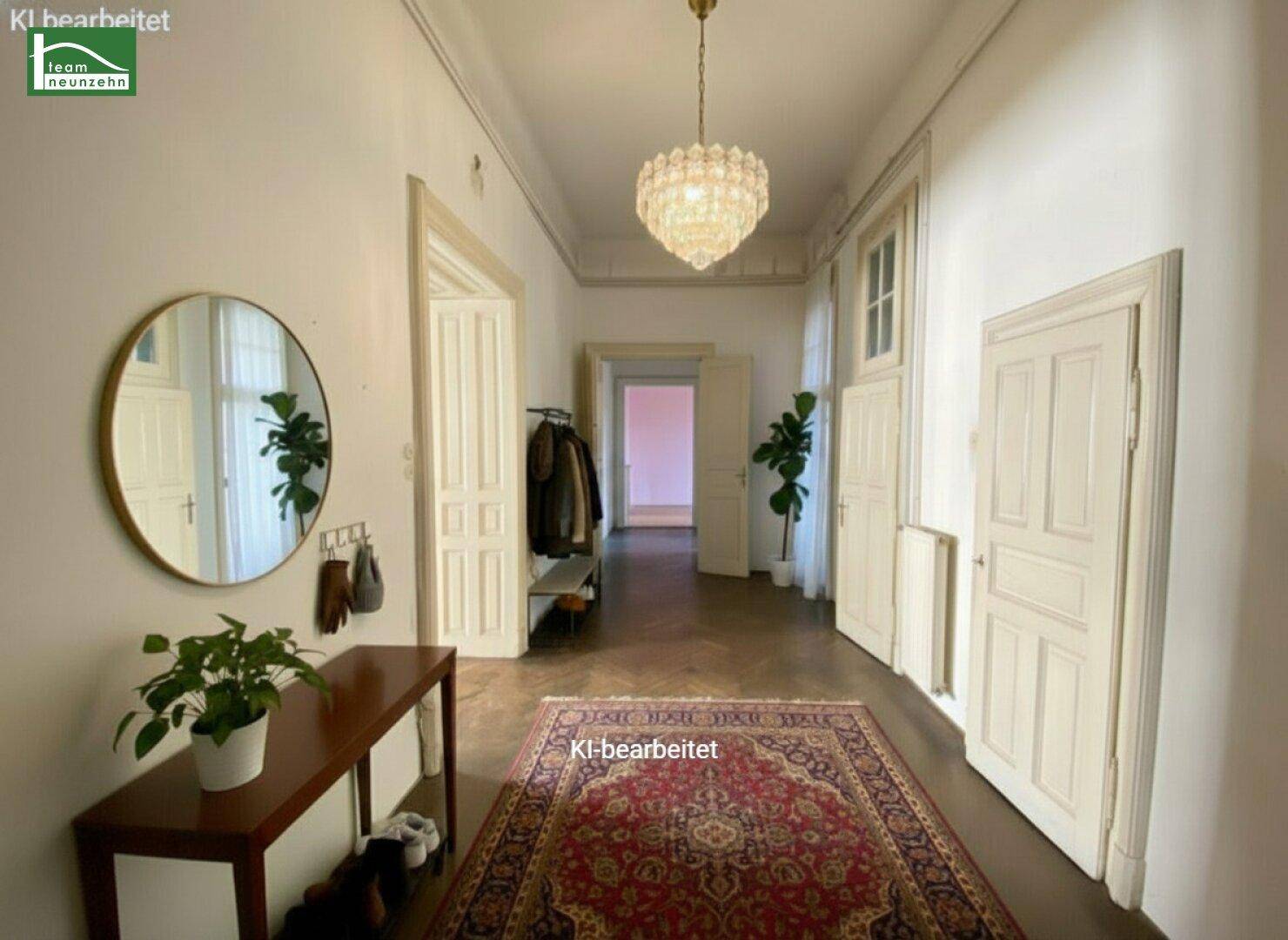 Heller Flur mit elegantem Kronleuchter, großem Spiegel und traditionellem Teppich.