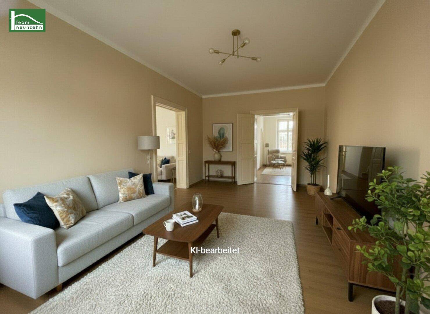 Helles Wohnzimmer mit Sofa, Couchtisch und Blick in angrenzende Räume.