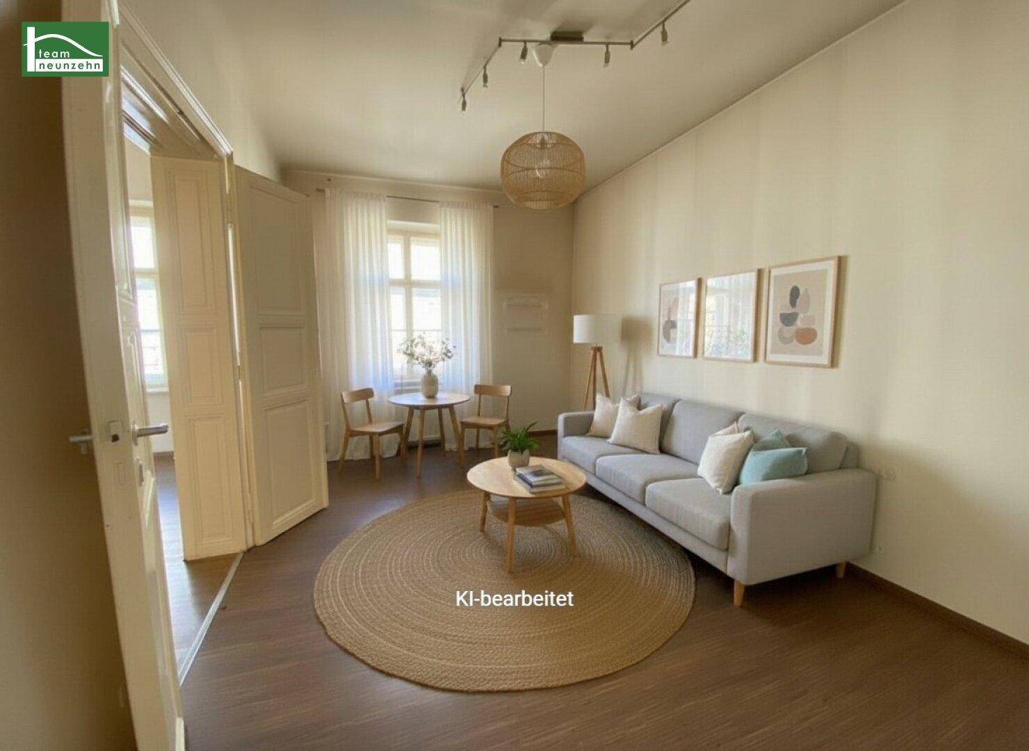 Gemütliches Wohnzimmer mit Sofa, rundem Teppich und kleinem Essbereich am Fenster.
