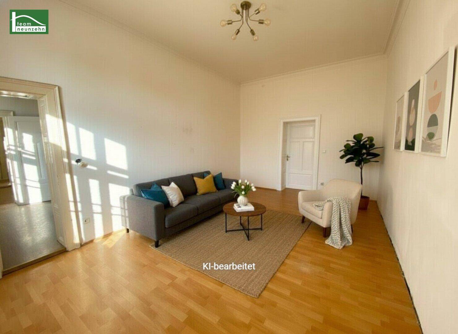 Helles Wohnzimmer mit Sofa, Sessel und Blick auf den Eingangsbereich.