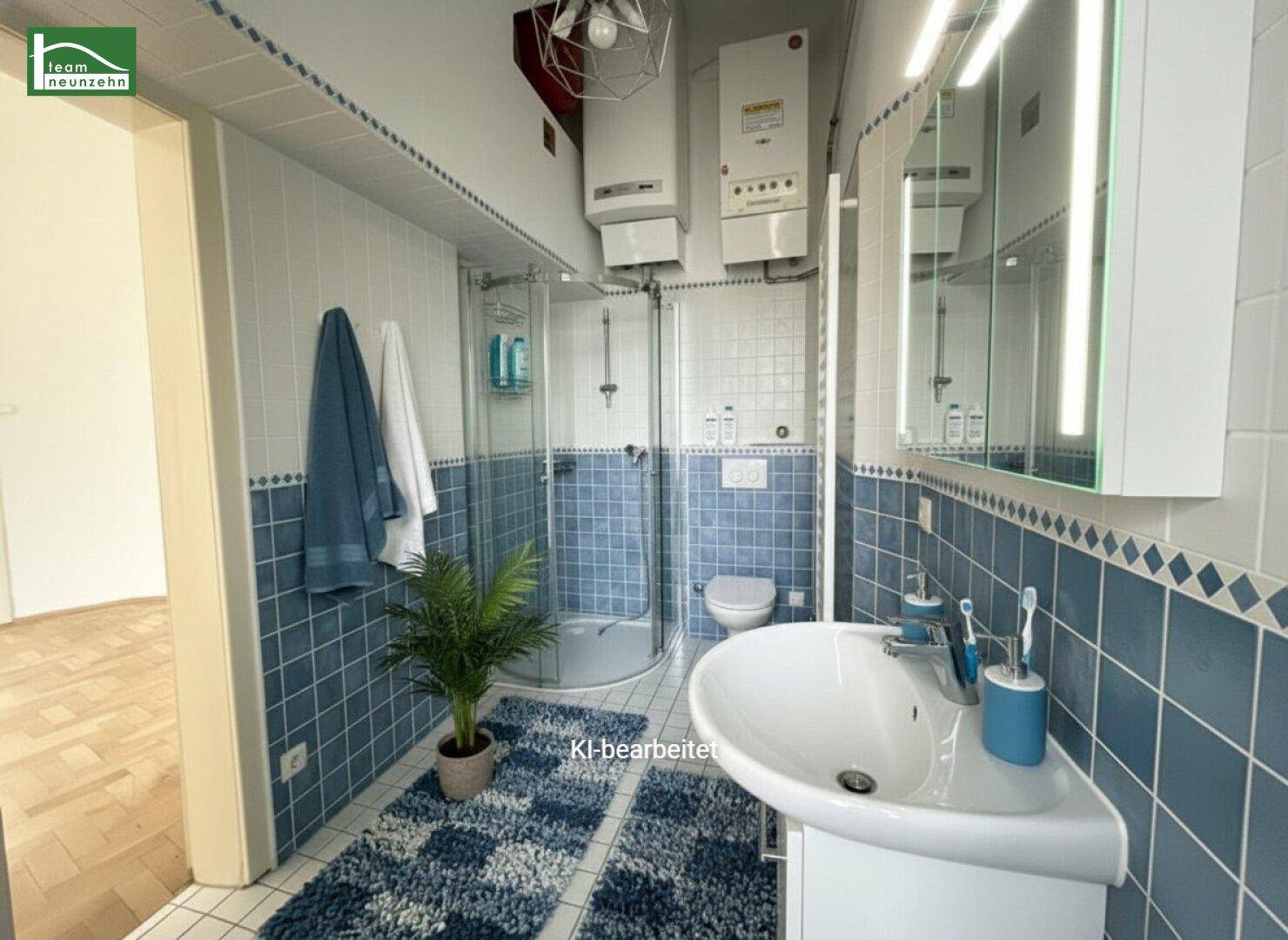 Funktionales Badezimmer mit blauen und weißen Fliesen, Dusche und Waschbecken, dekoriert.