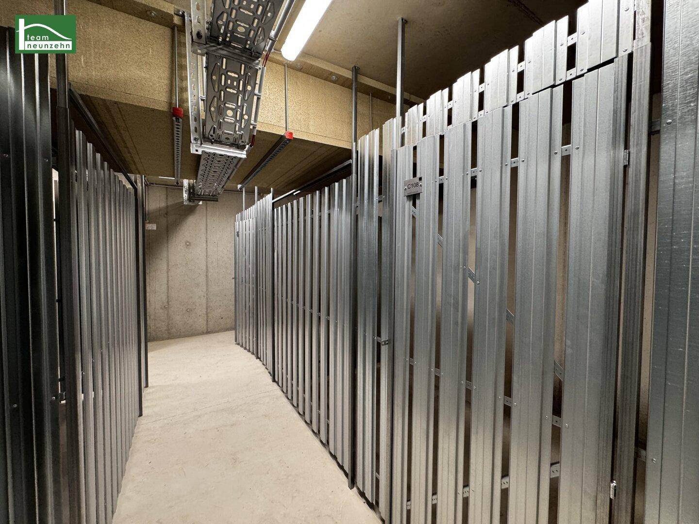 Abstellräume mit Metallabtrennungen in einem Kellerbereich, ideal für zusätzlichen Stauraum.