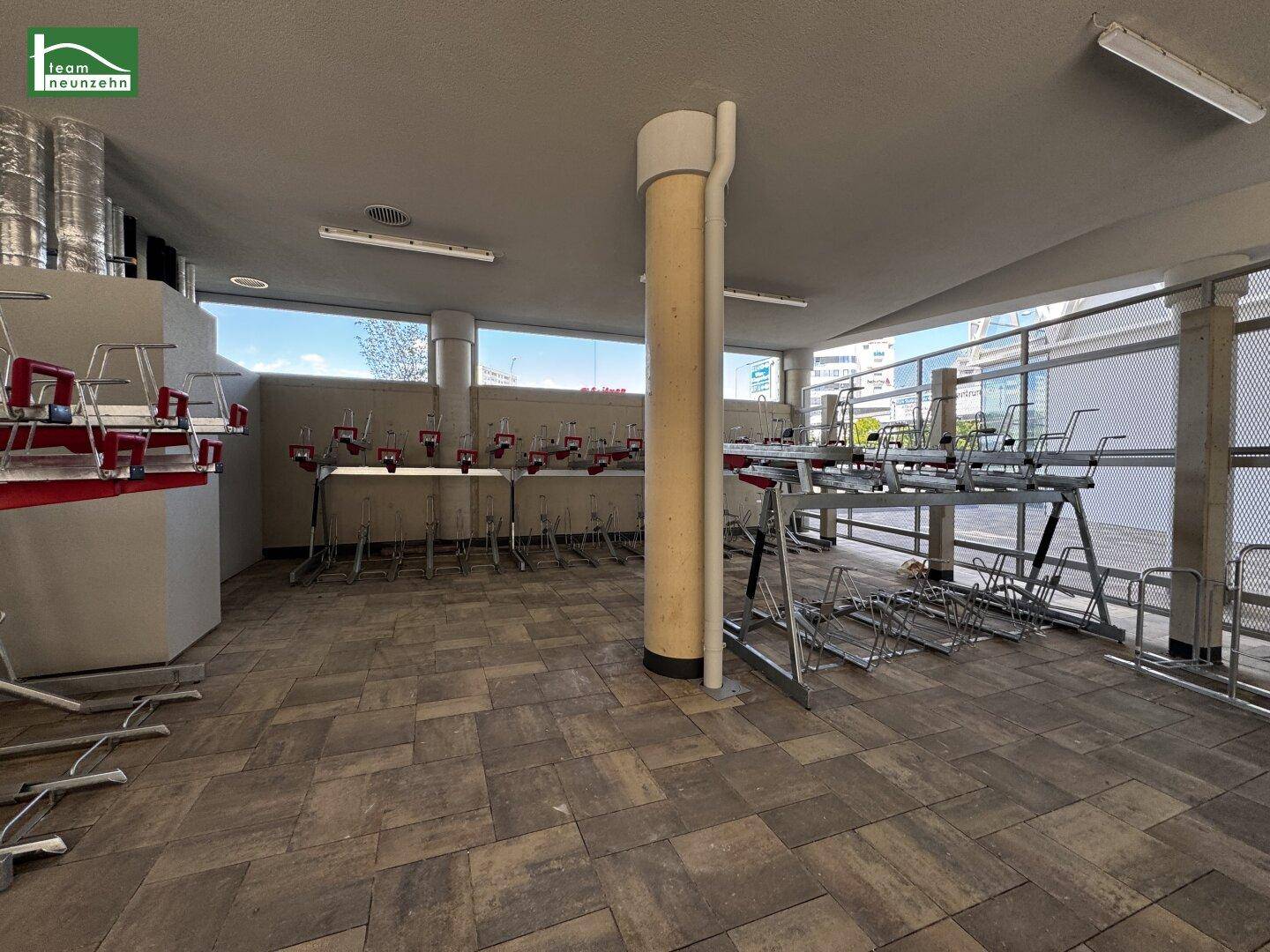 Geräumiger Fahrradraum mit zahlreichen Abstellmöglichkeiten und gepflastertem Boden.