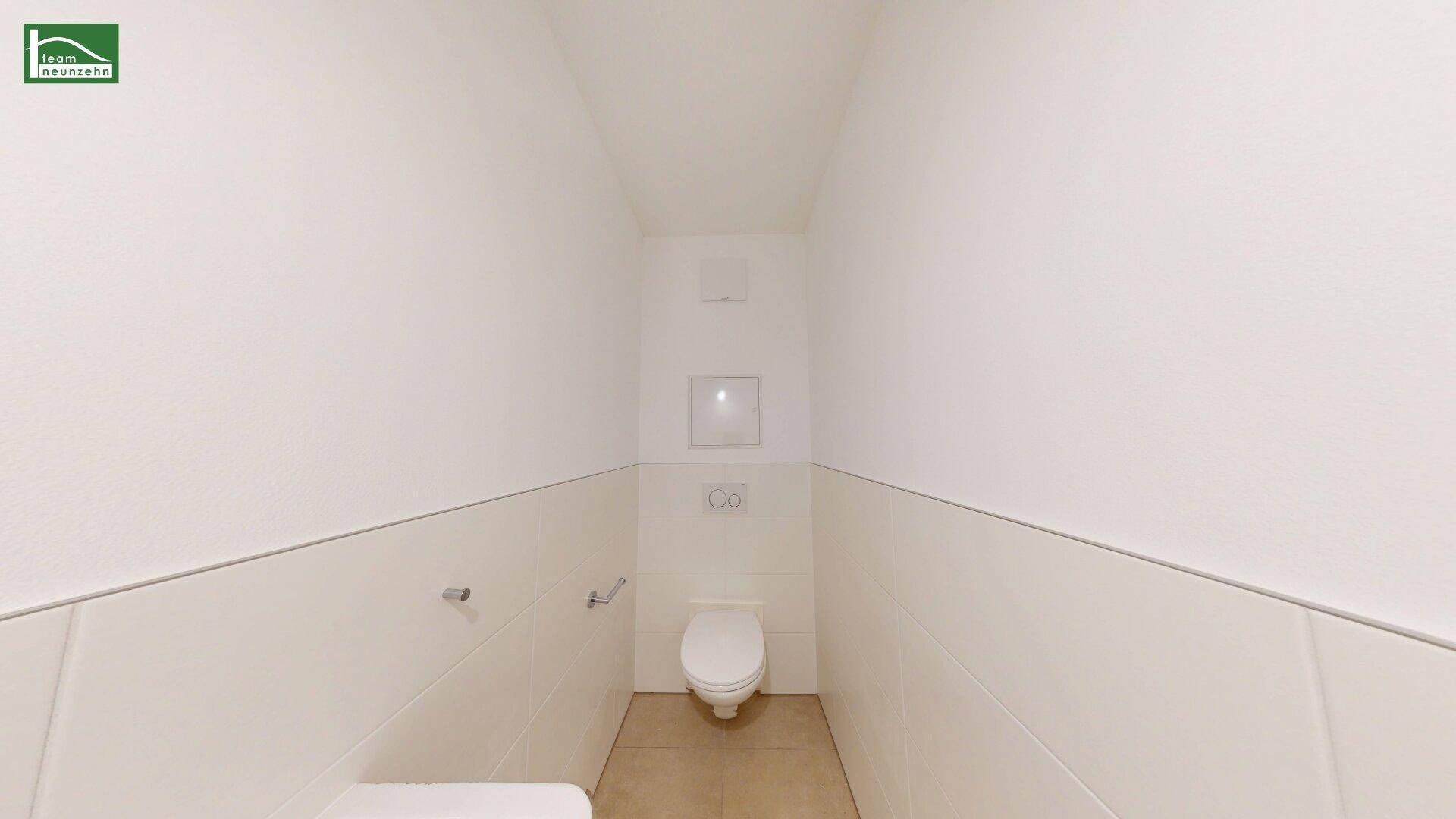 Separates WC mit Wand-WC und hellen Fliesen, funktional und sauber gestaltet.