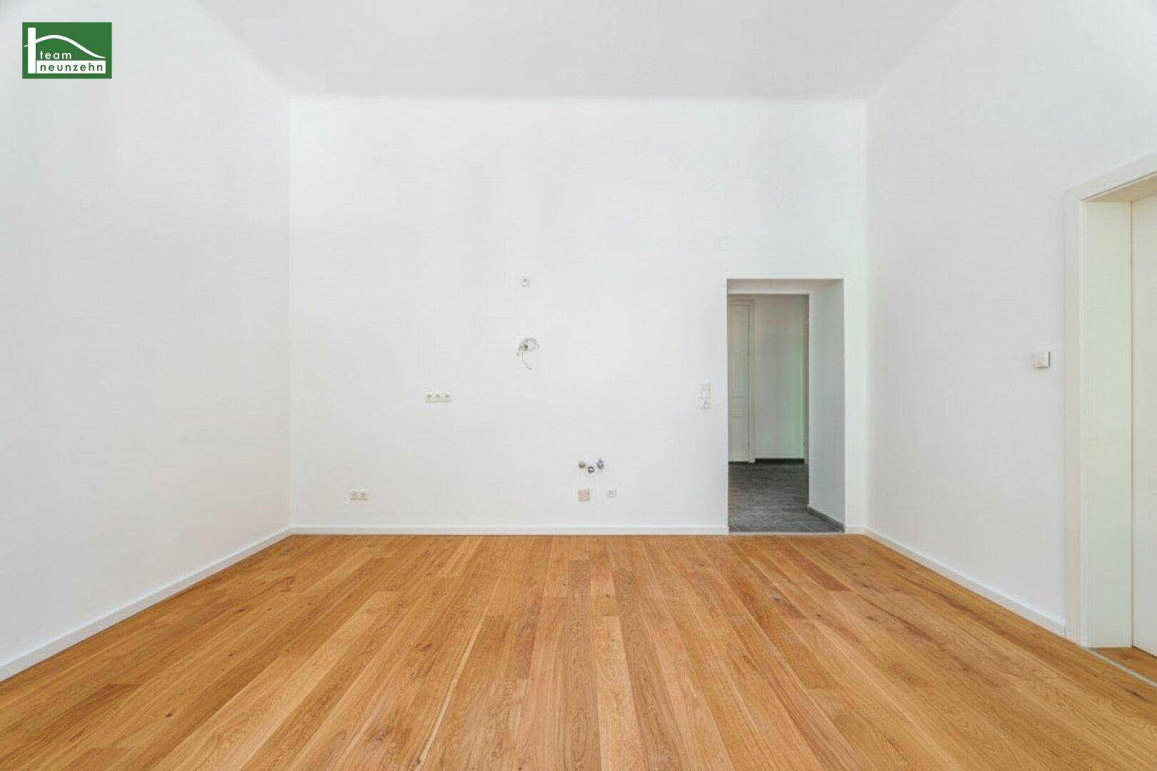 Heller, leerer Raum mit Holzboden und weißen Wänden, bereit zur individuellen Gestaltung.