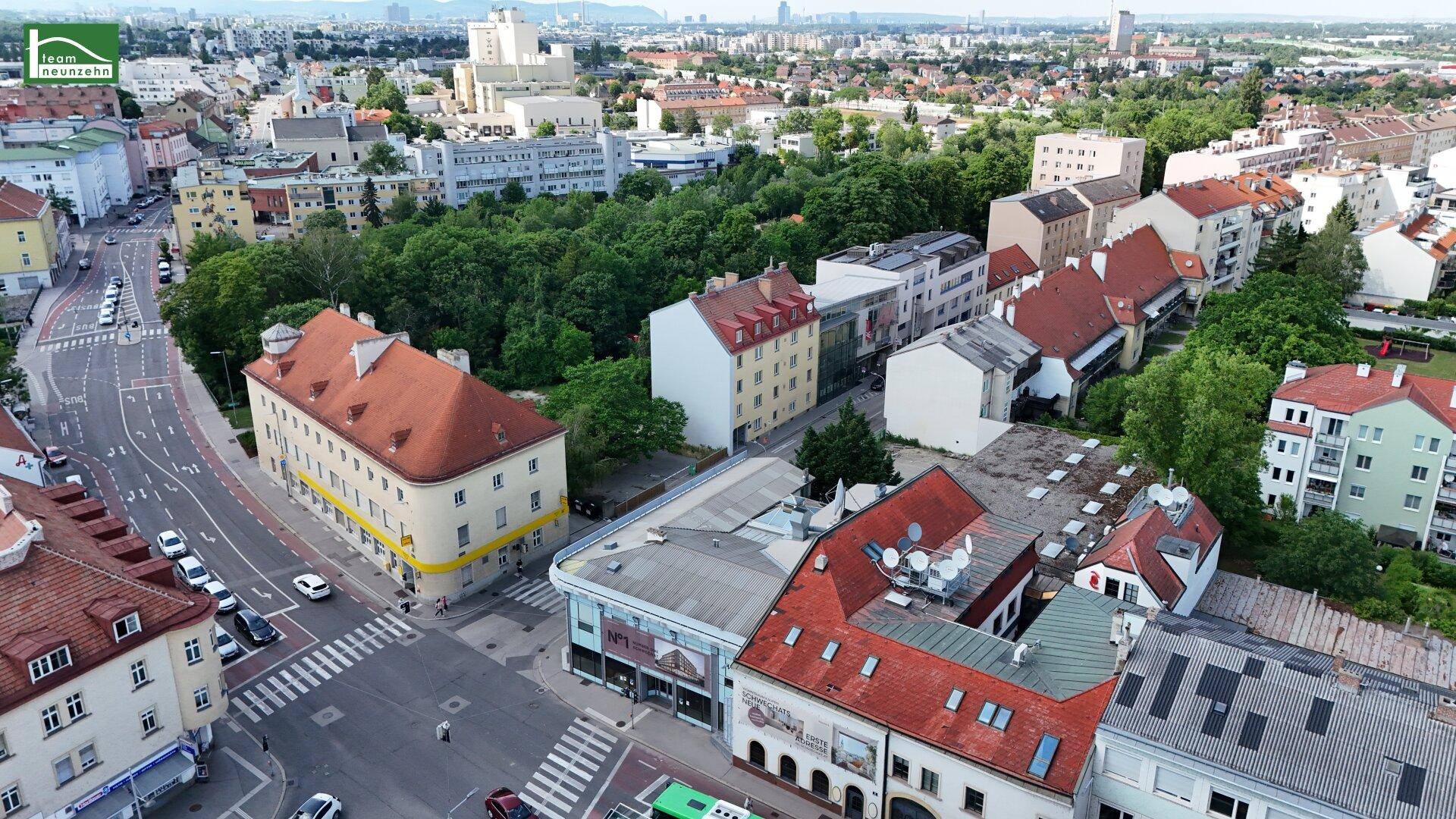 Luftaufnahme einer städtischen Umgebung mit Wohngebäuden, Straßen und Grünflächen.
