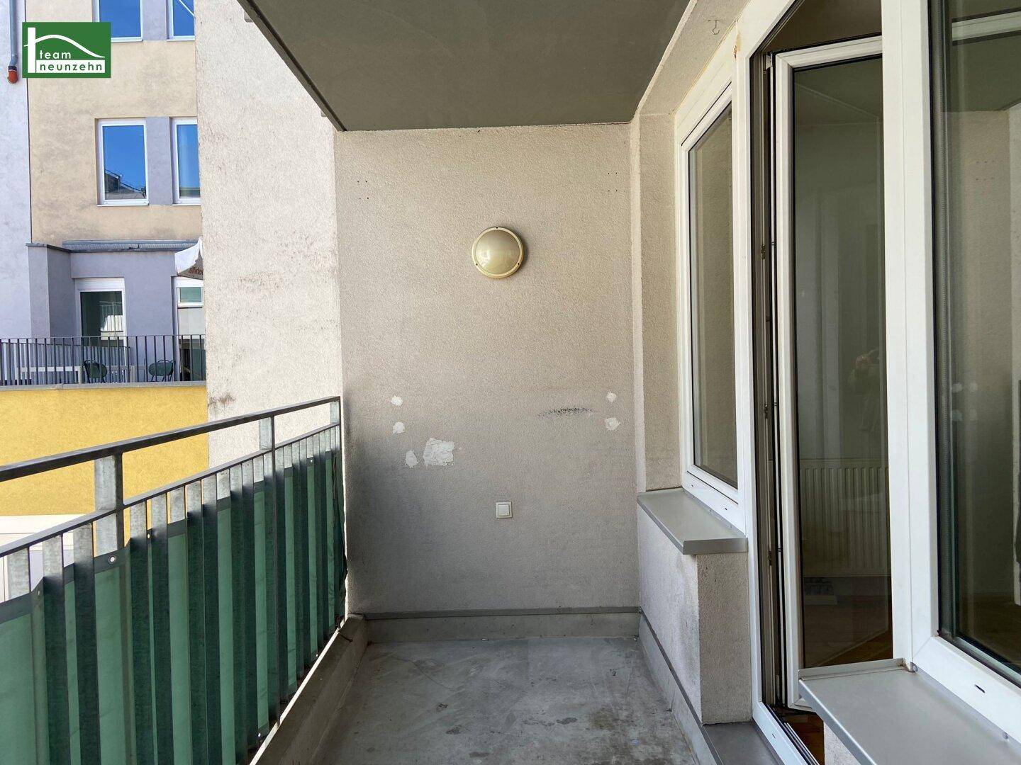 Kleiner Balkon mit Metallgeländer und Blick auf die umliegenden Gebäude.
