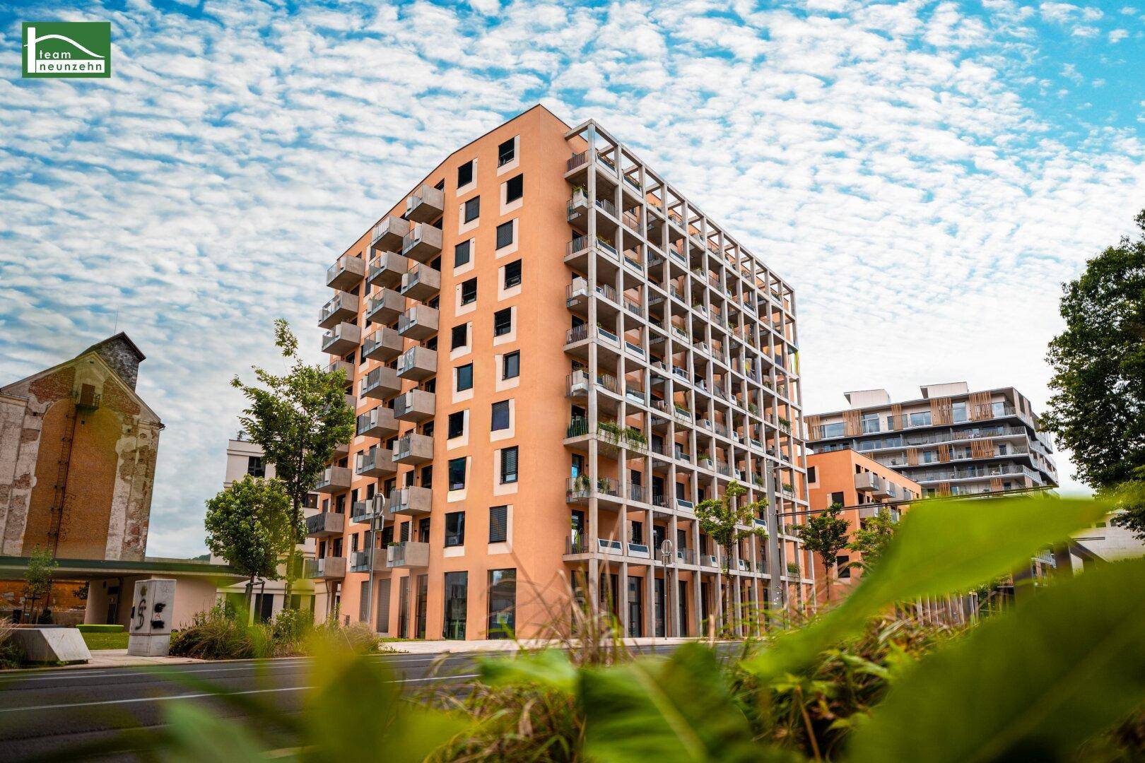 Moderne Wohngebäude mit zahlreichen Balkonen und zeitgenössischer Architektur unter blauem Himmel.