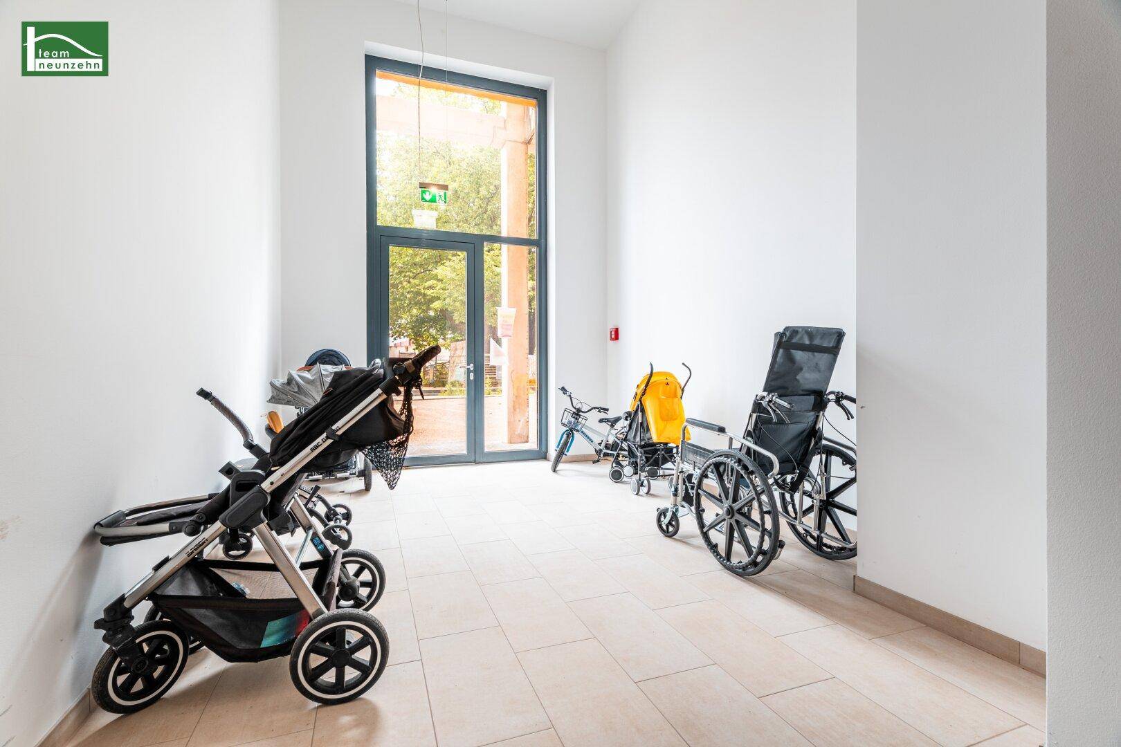 Gemeinschaftsraum für Kinderwagen und Rollstühle mit großem Fenster.