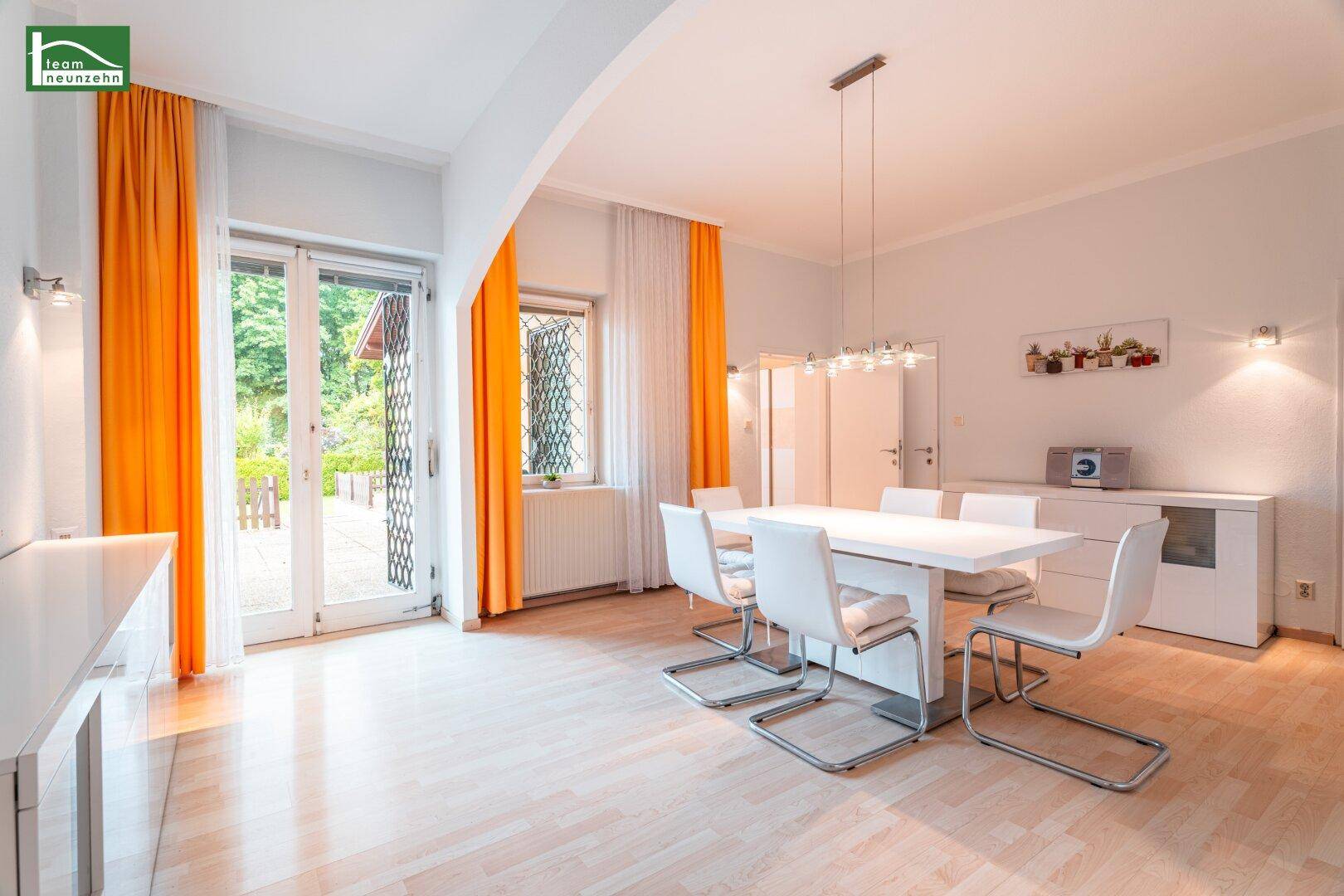 Heller Essbereich mit modernem weißen Esstisch, Stühlen und Zugang zur Terrasse.