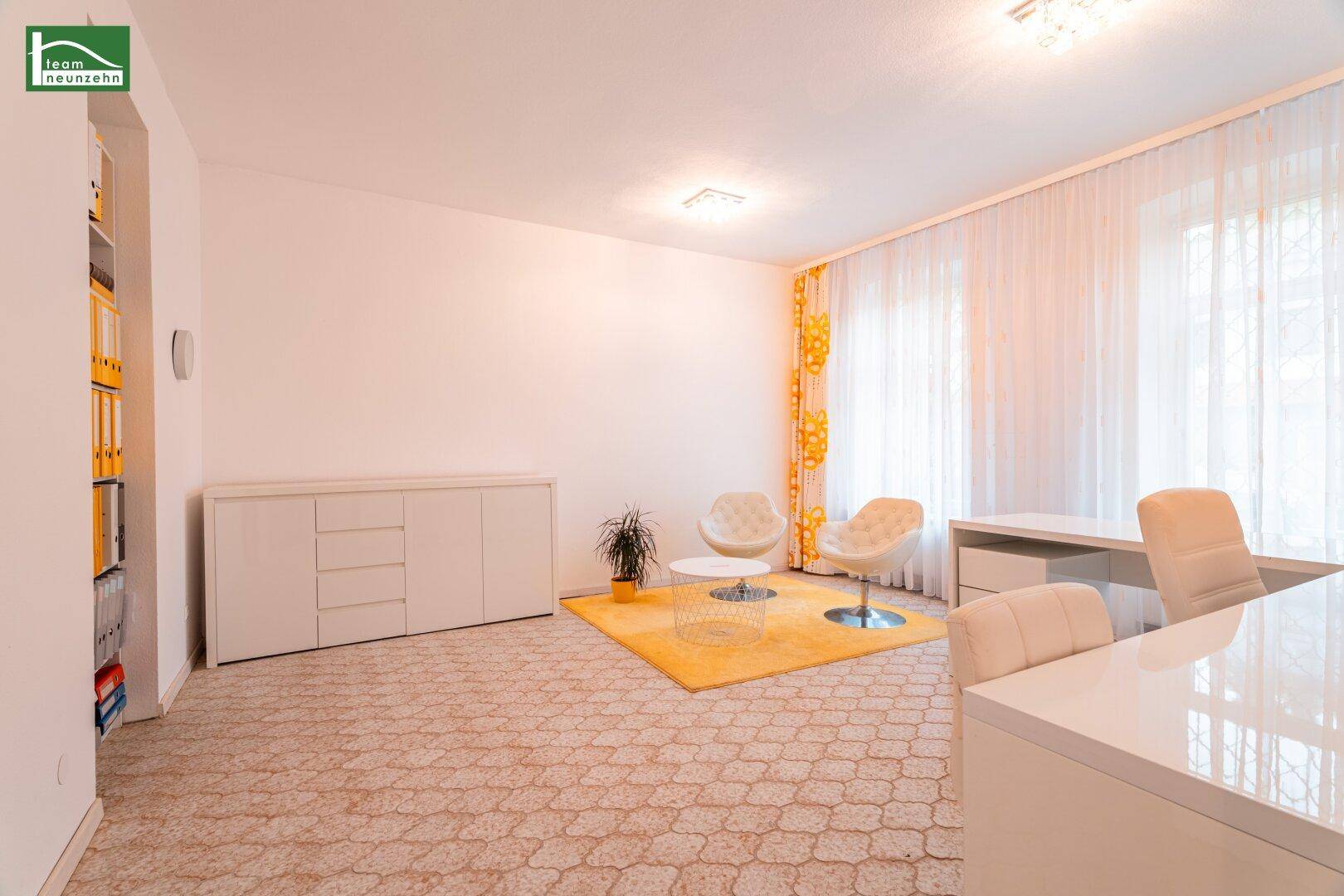 Geräumiges Arbeitszimmer mit Teppichboden, weißen Möbeln und einem auffälligen gelben Teppich.