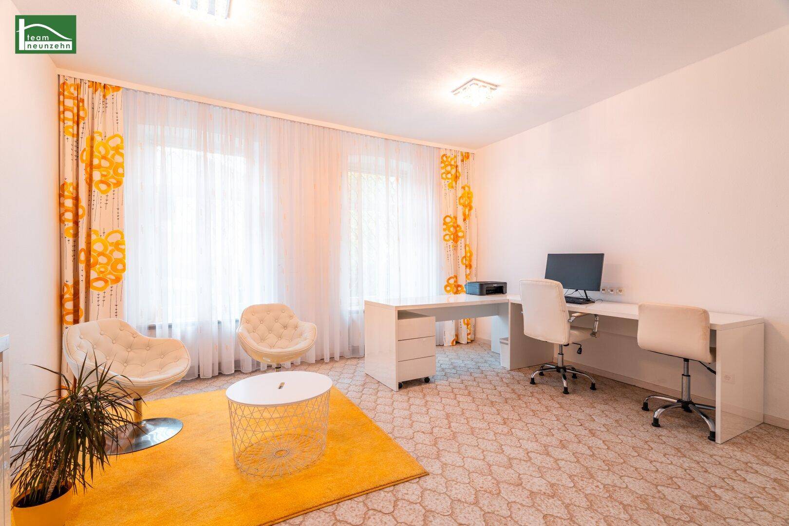 Helles Arbeitszimmer mit zwei Schreibtischen, bequemen Sesseln und gelben Akzenten.