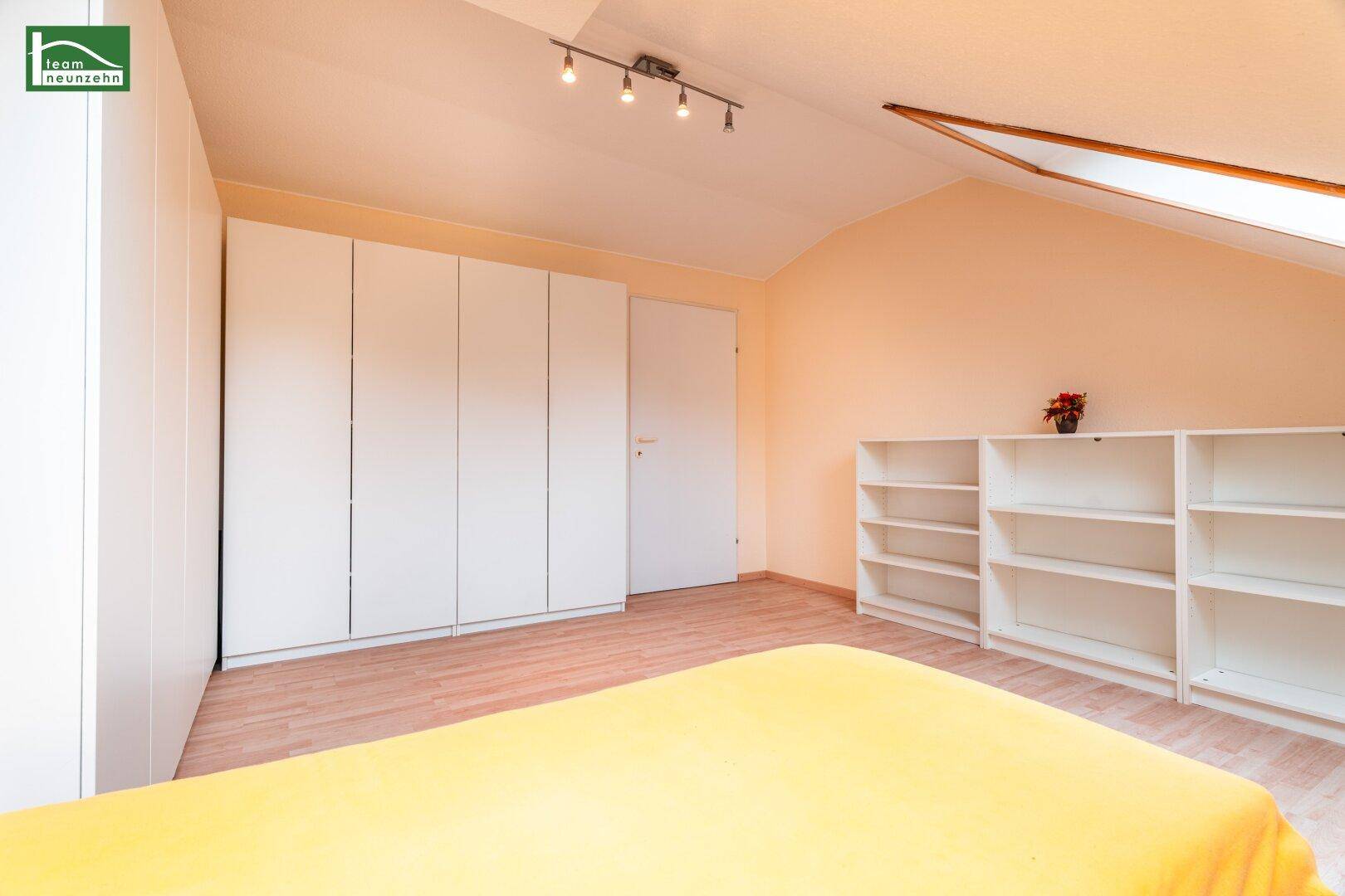 Dachgeschoss-Schlafzimmer mit viel Stauraum durch Einbauschränke und Regale.