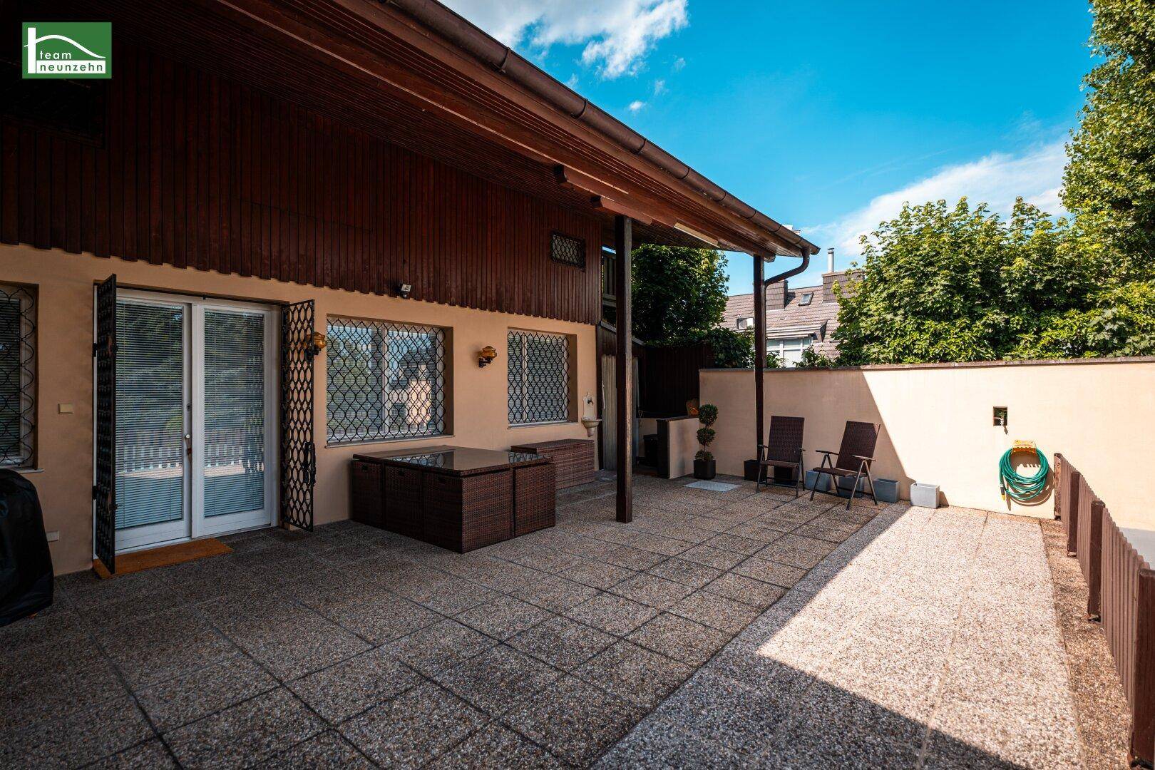 Geräumige gepflasterte Terrasse am Haus mit Sitzgelegenheiten und einem überdachten Bereich für Entspannung.