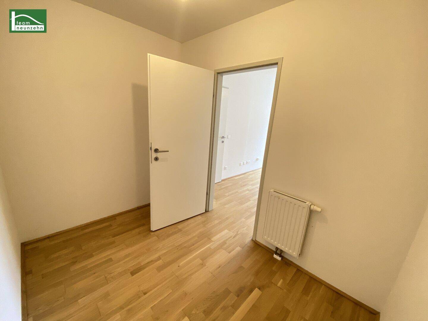 Kleiner, heller Raum mit Parkettboden und einer Tür, vielseitig nutzbar.