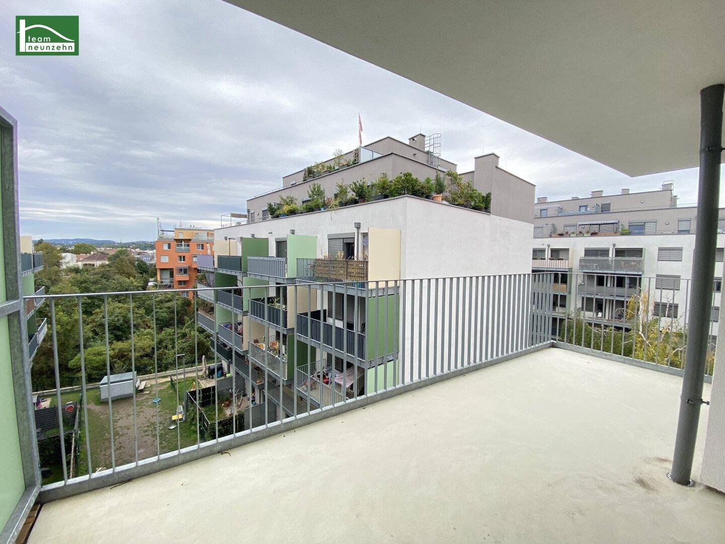 Blick vom Balkon auf die umliegenden Gebäude und grüne Innenhöfe der Wohnanlage.