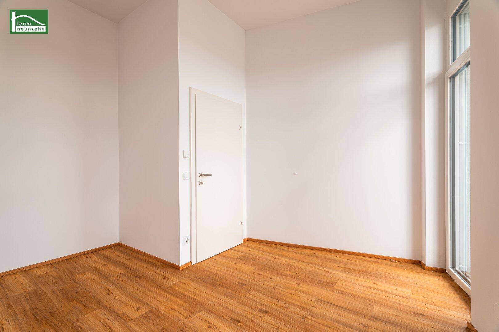 Leeres Zimmer mit Holzboden und weiß gestrichenen Wänden, bietet vielseitige Nutzungsmöglichkeiten.
