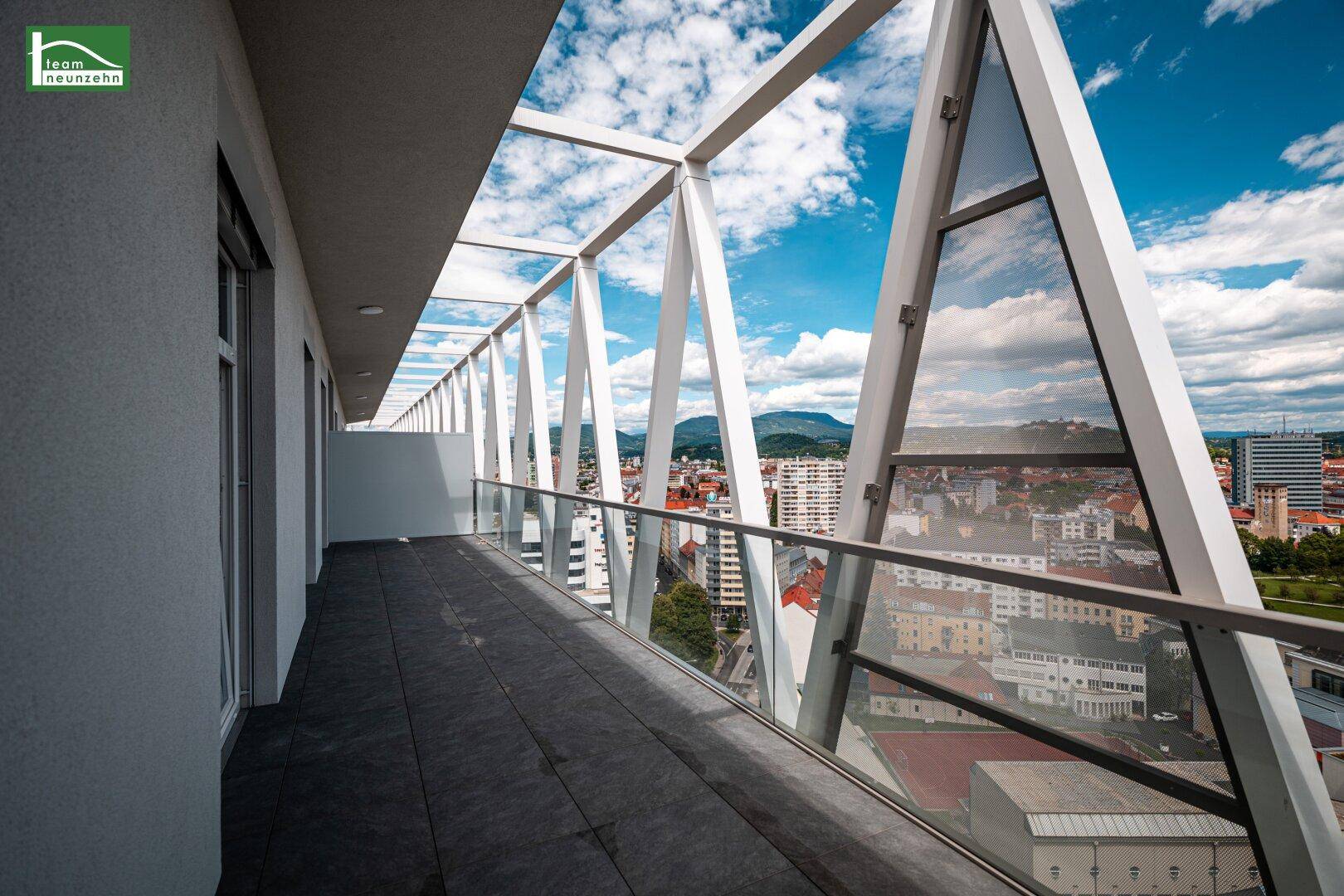 Geräumiger Balkon mit einzigartiger Architektur und beeindruckendem Panoramablick auf Stadt und Berge.