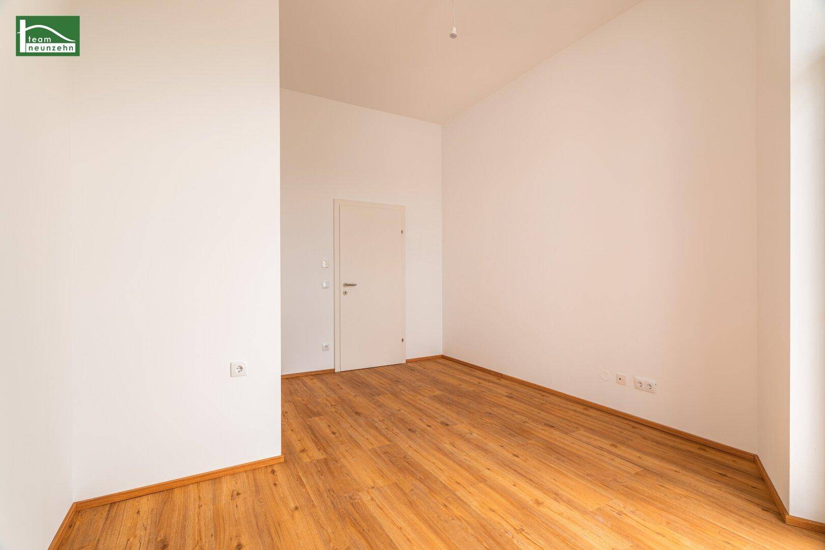 Unmöbliertes Zimmer mit Holzboden und weißen Wänden, ideal für Schlafzimmer oder Büro.