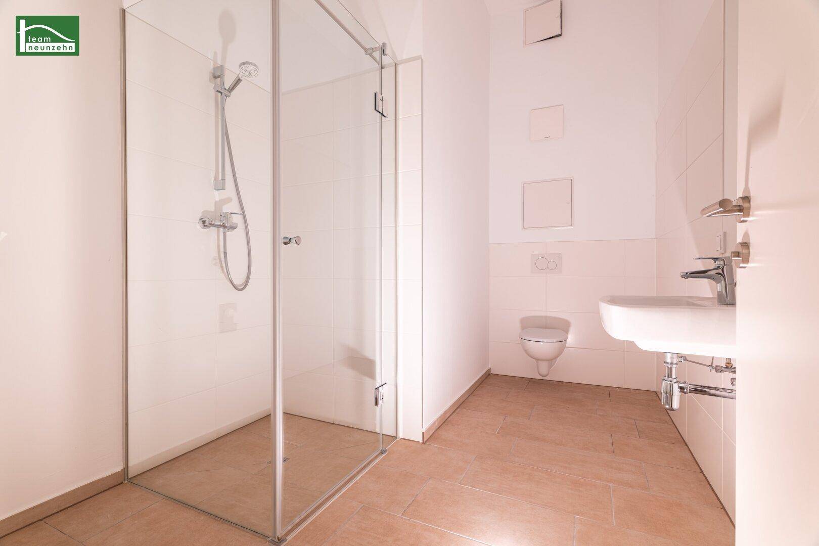 Helles Badezimmer mit Glasdusche, wandhängendem WC und modernem Waschtisch.
