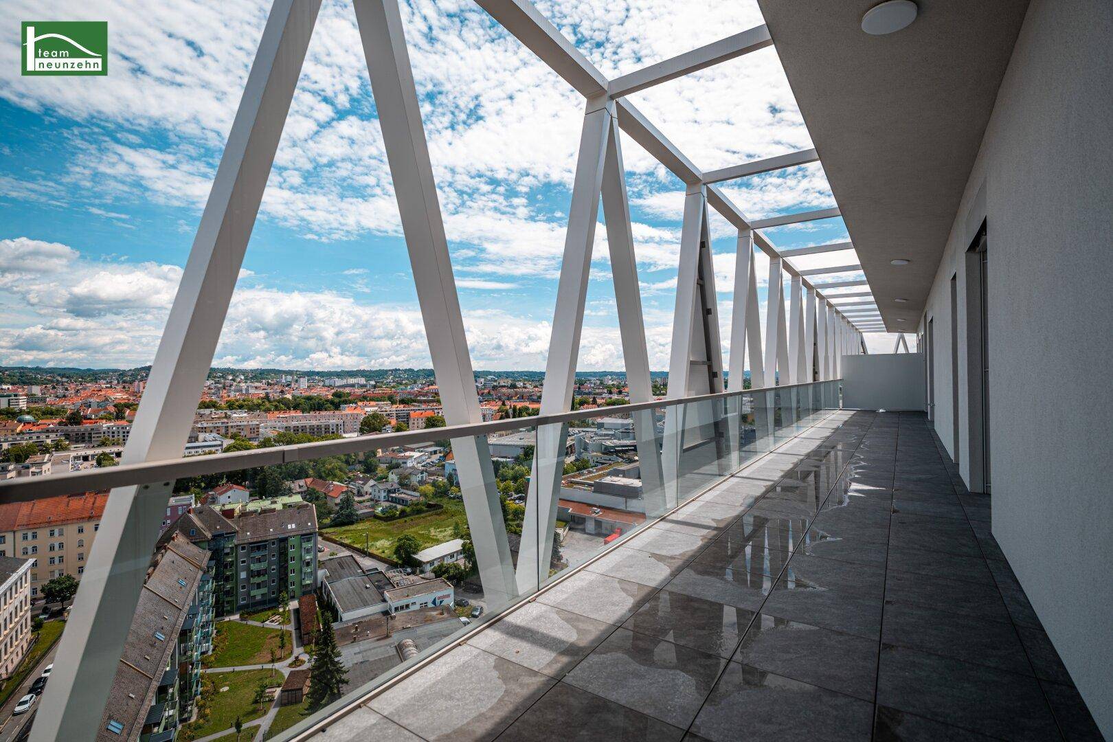 Geräumige Terrasse mit moderner Architektur und Panoramablick auf die Stadt und Berge.