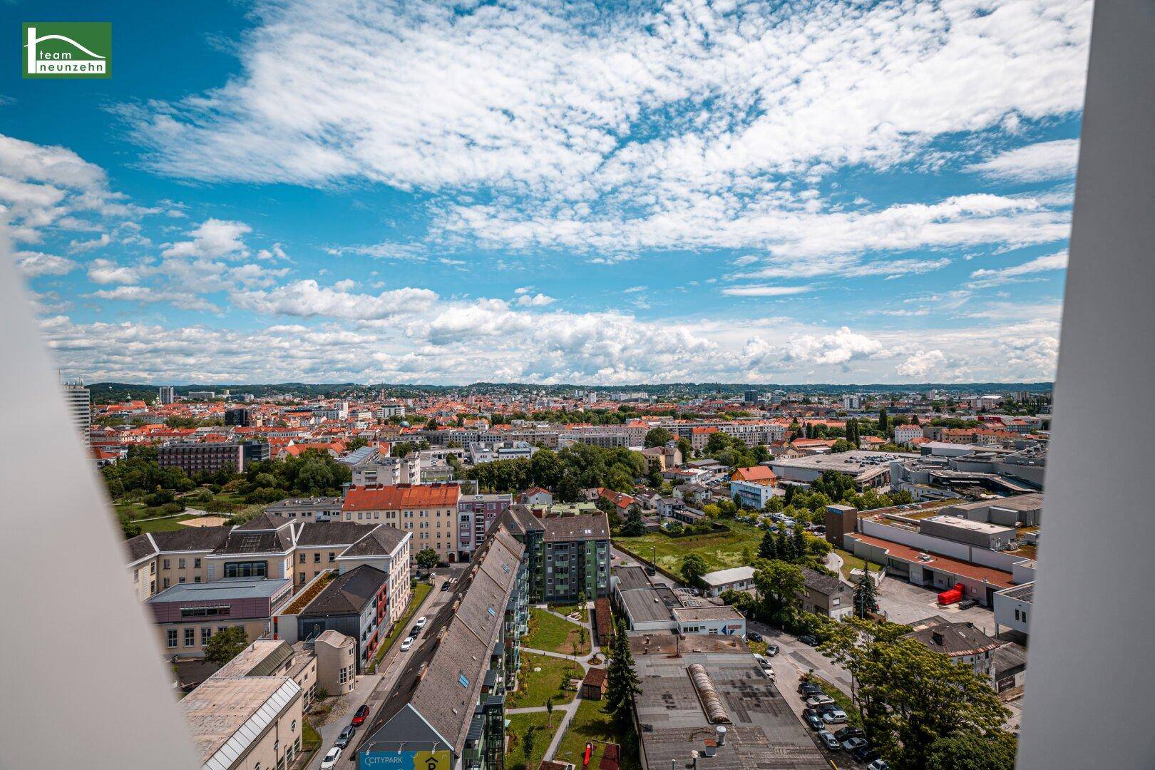 Panoramablick über eine Stadtlandschaft mit vielen Gebäuden und einem blauen Himmel.