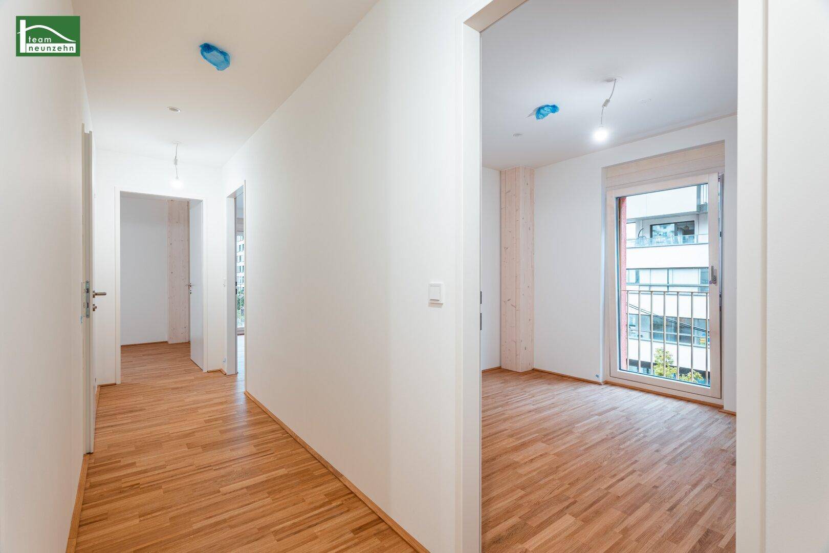Heller Flur mit Parkettboden, der zu verschiedenen Zimmern der Wohnung führt.